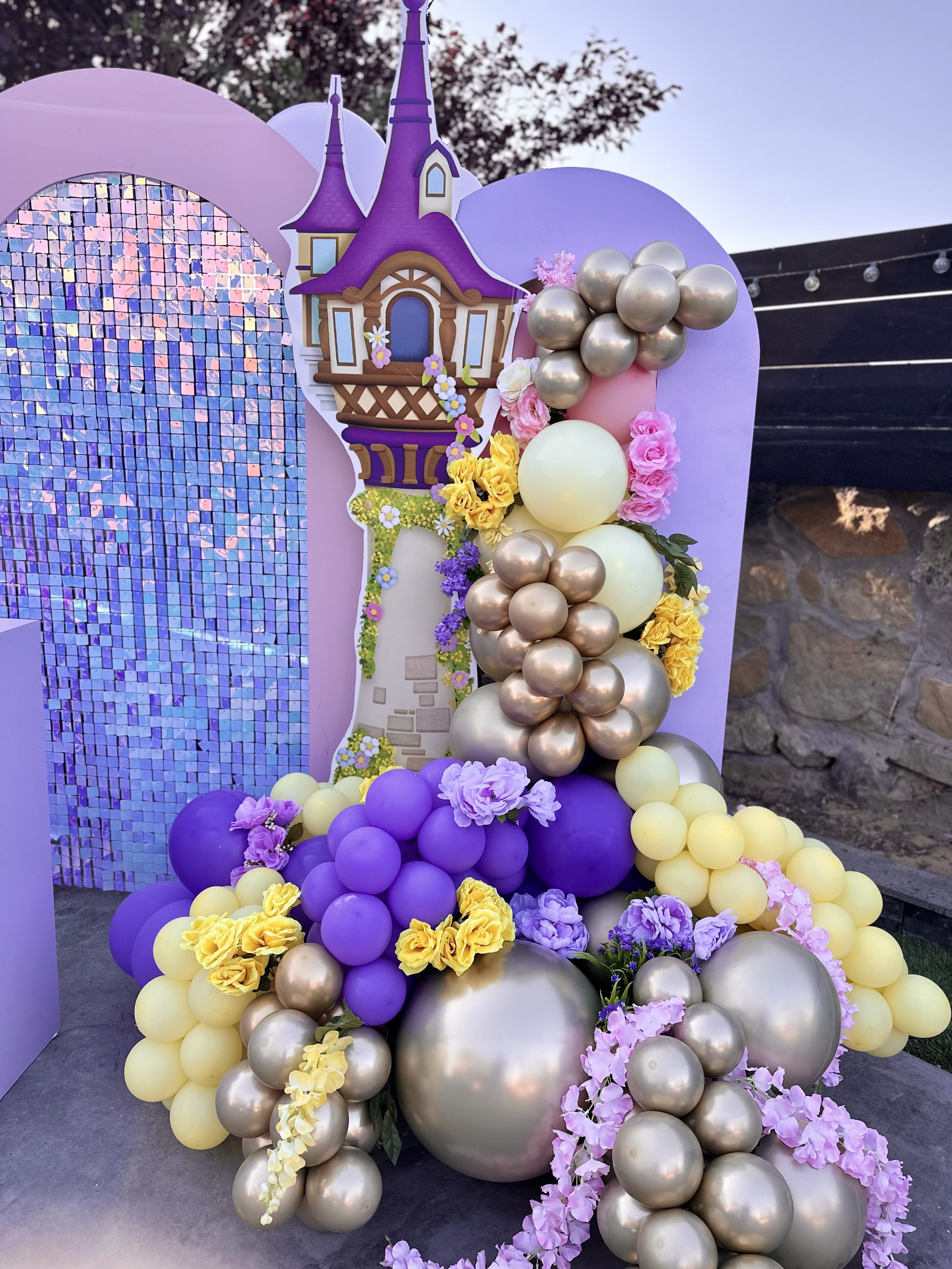 Decorative balloon arrangement and a castle-themed cutout for a fairy tale or princess-themed event.