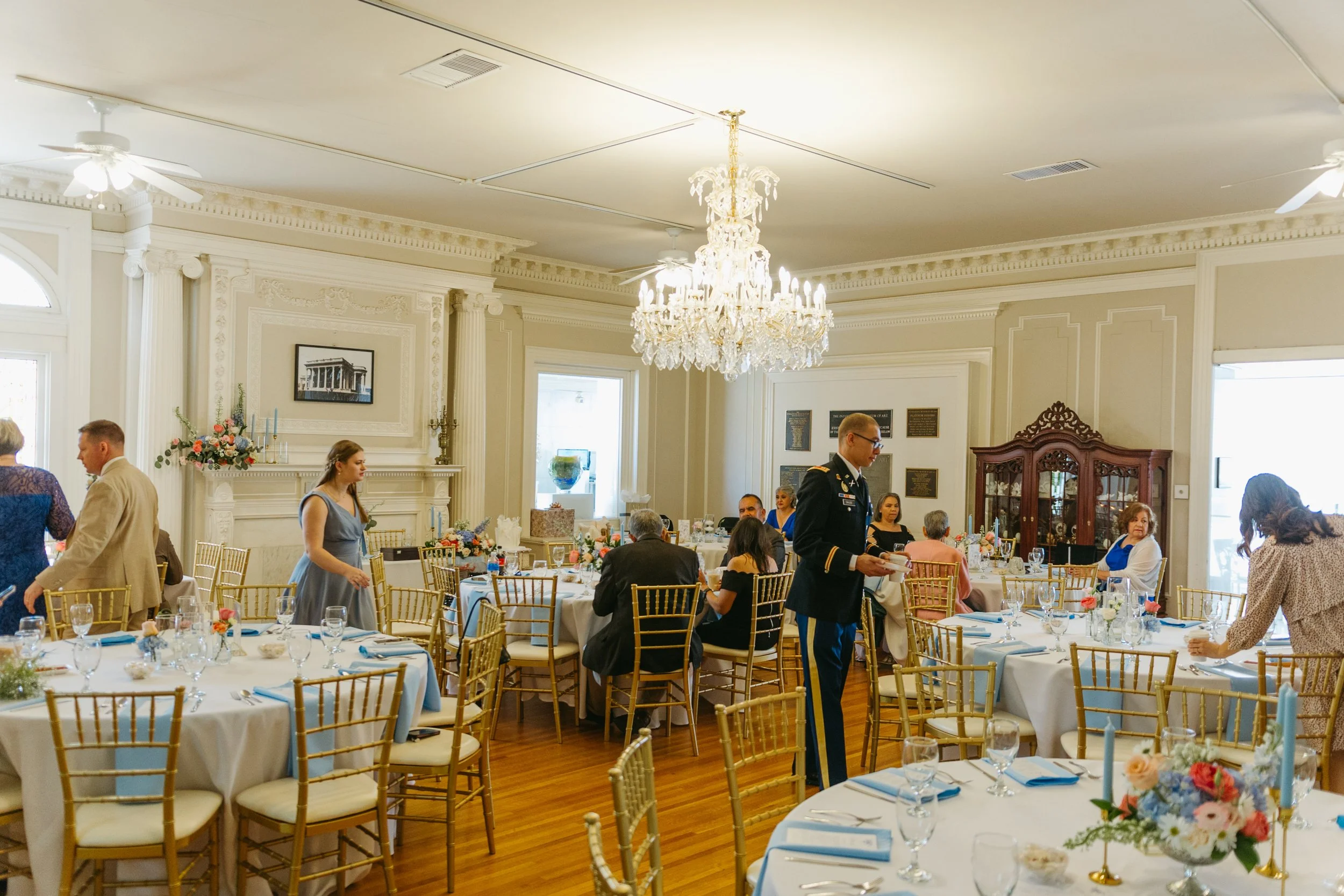 Elegant banquet hall with round tables decorated with floral centerpieces, set for a formal event.