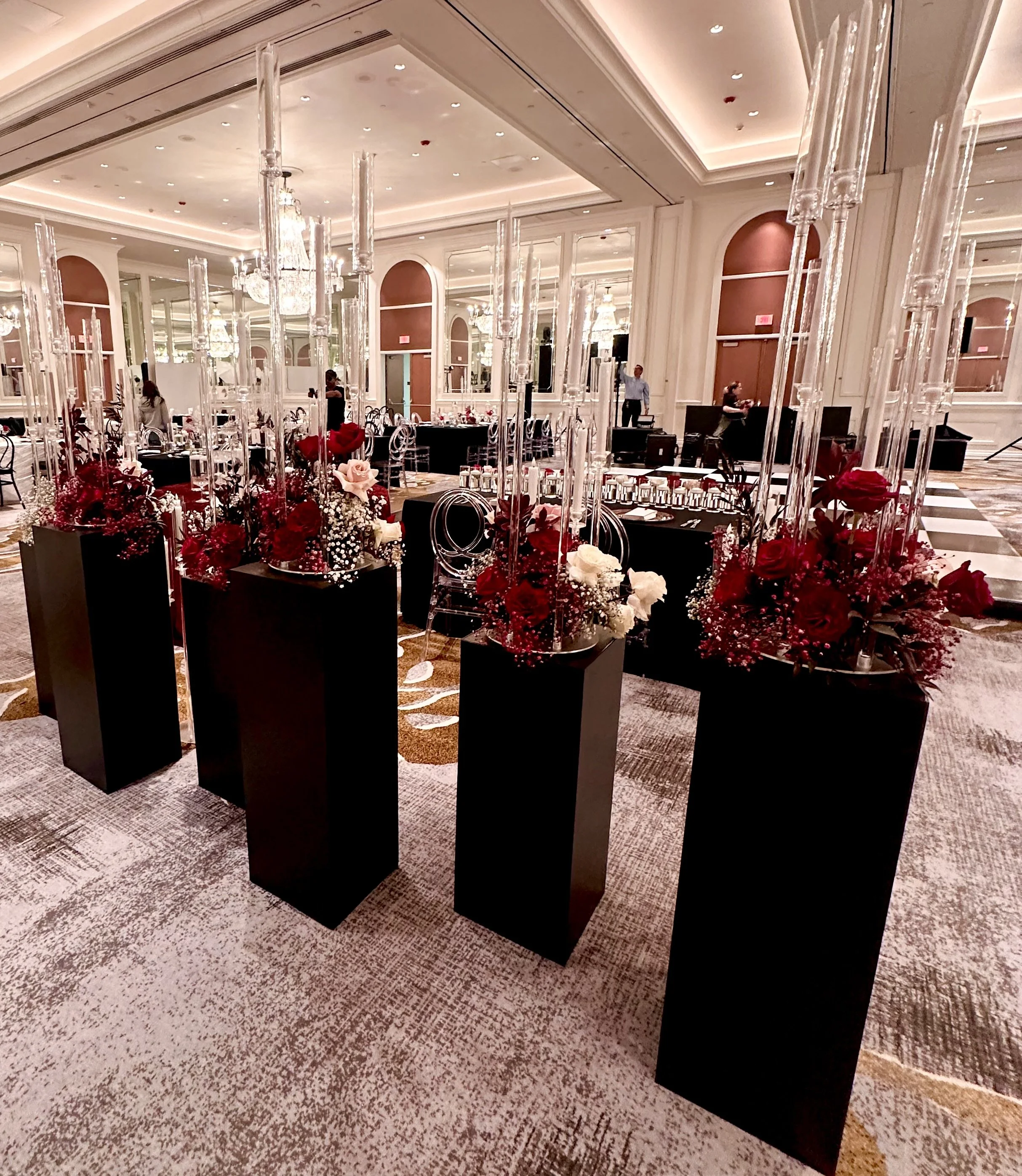 Elegant banquet hall decorated for a formal event with flower arrangements.