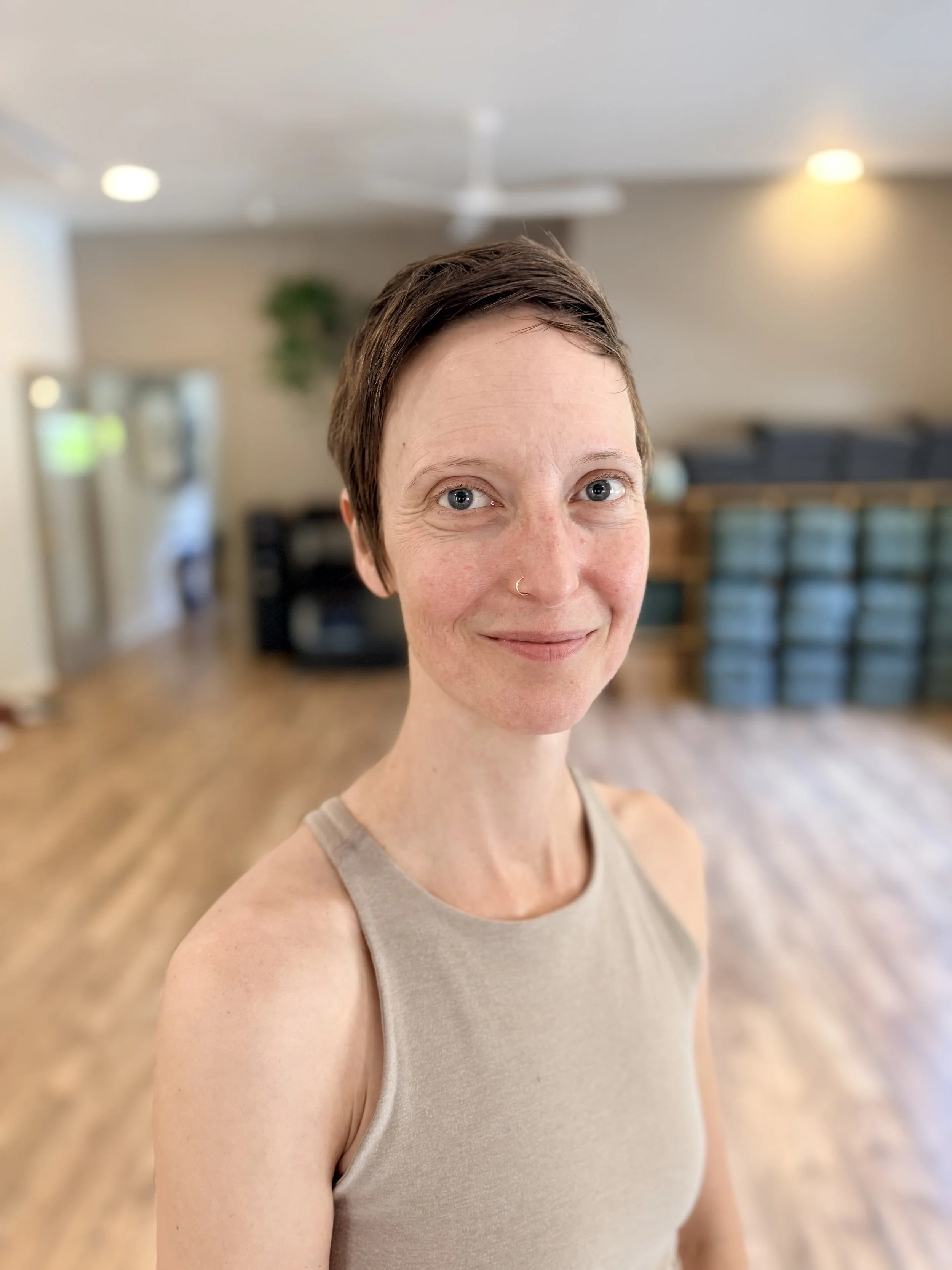 a nonbinary person smiling in a yoga room