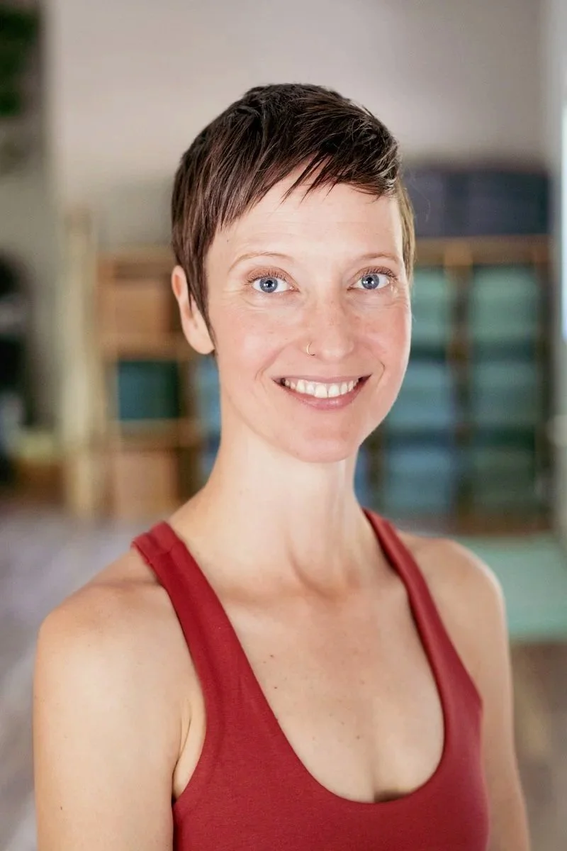 a nonbinary person smiling in a yoga room