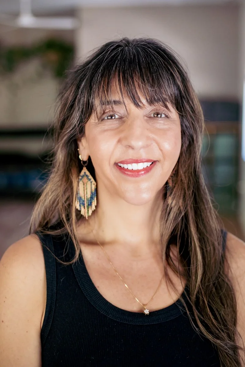 woman with brown hair smiling in a yoga studio