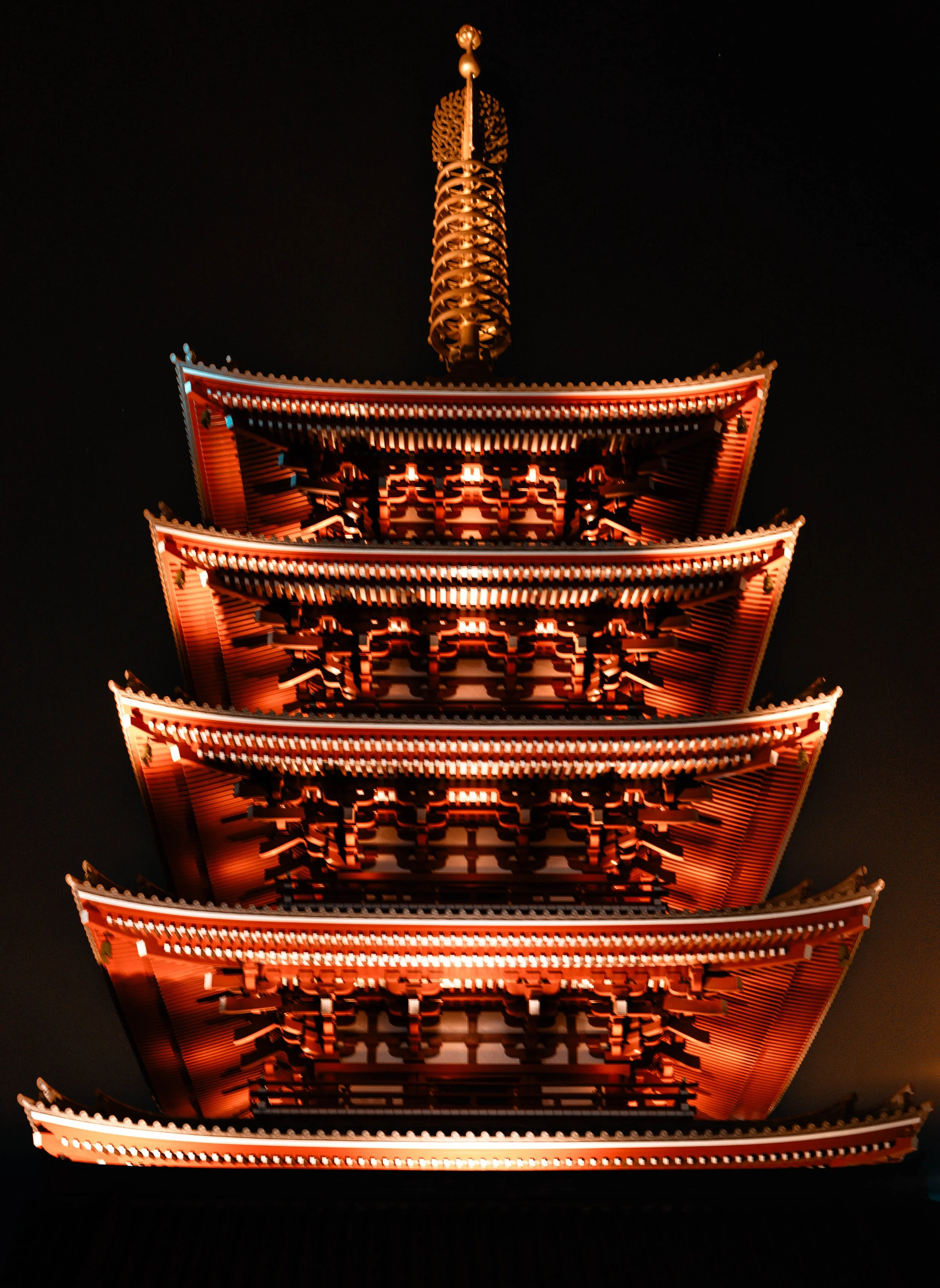 A brightly lit five-story pagoda at night, with a dark sky in the background.