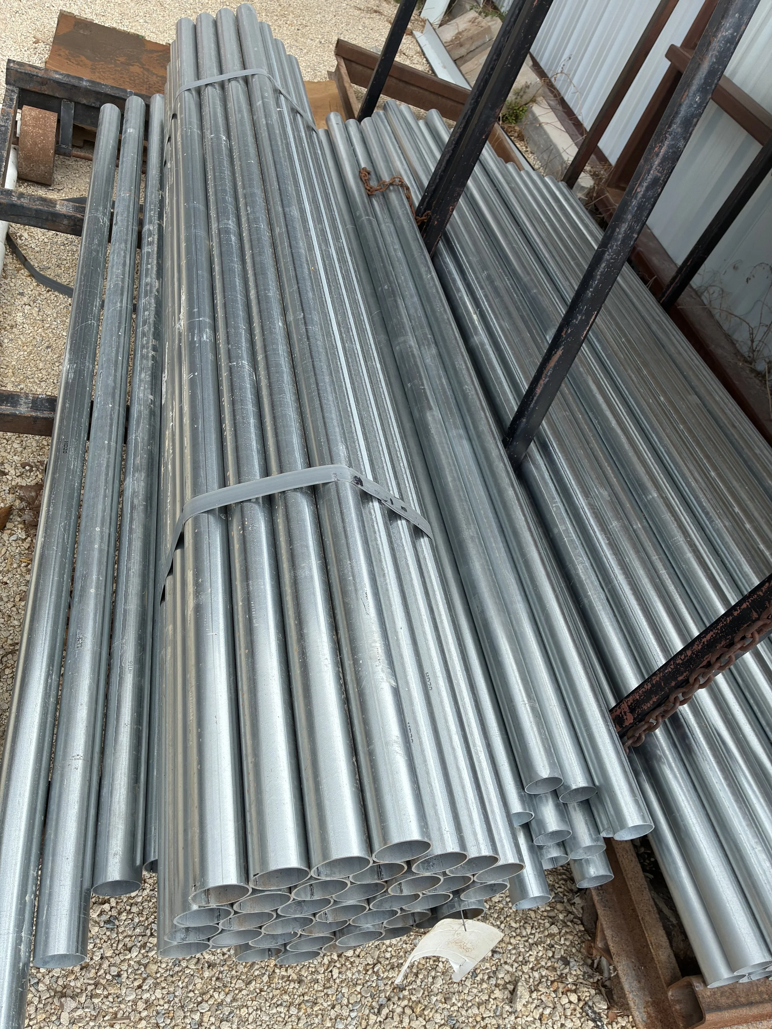 Stacks of 6' and 8' galvanized metal fence posts.