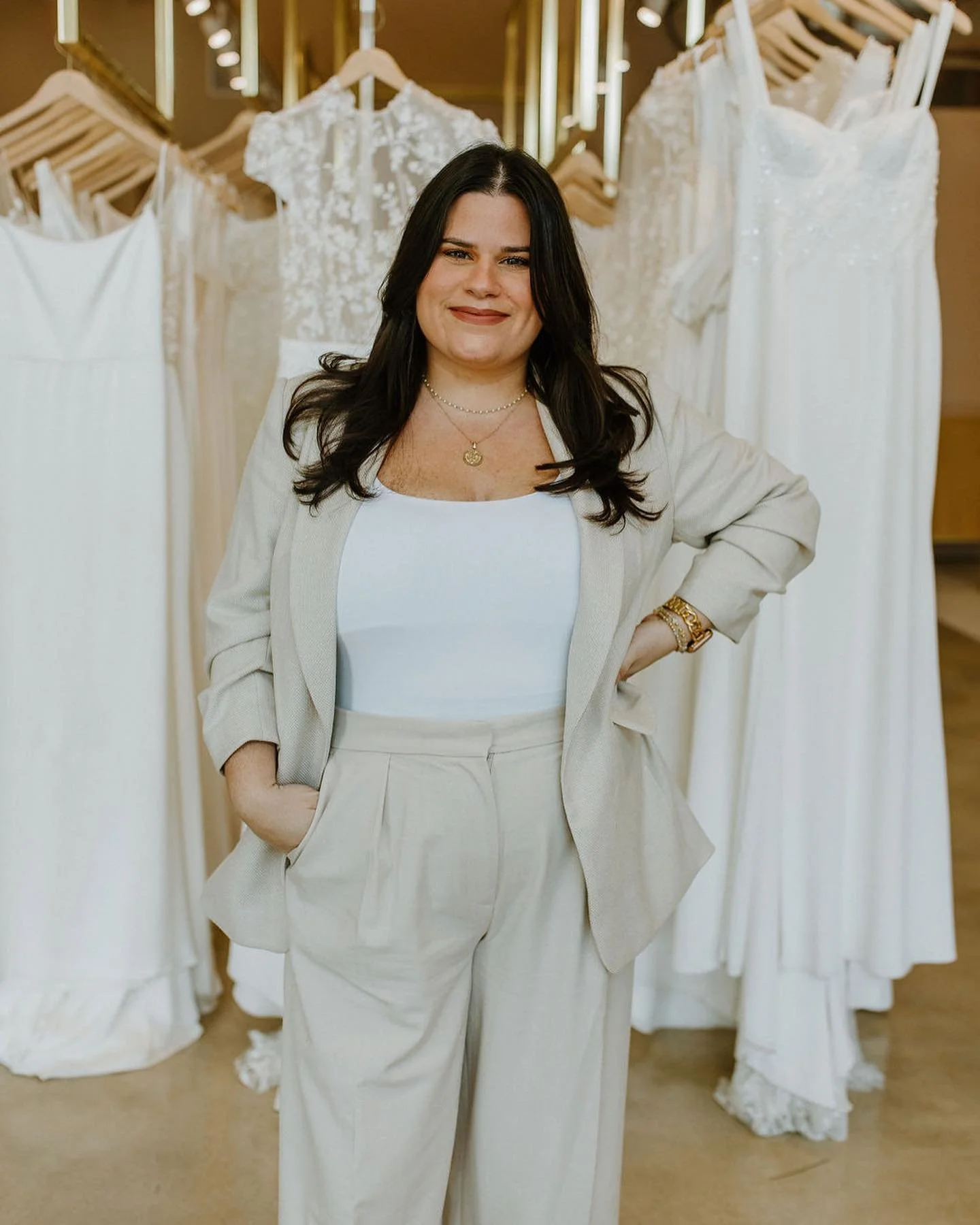Woman standing in front of a display of white wedding dresses.
