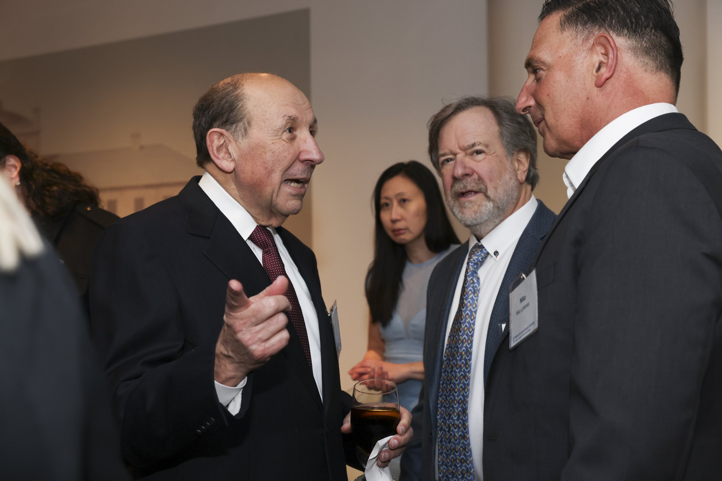 John Ranelli at event pointing and speaking to Niko Lahanas and Glen Axelrod