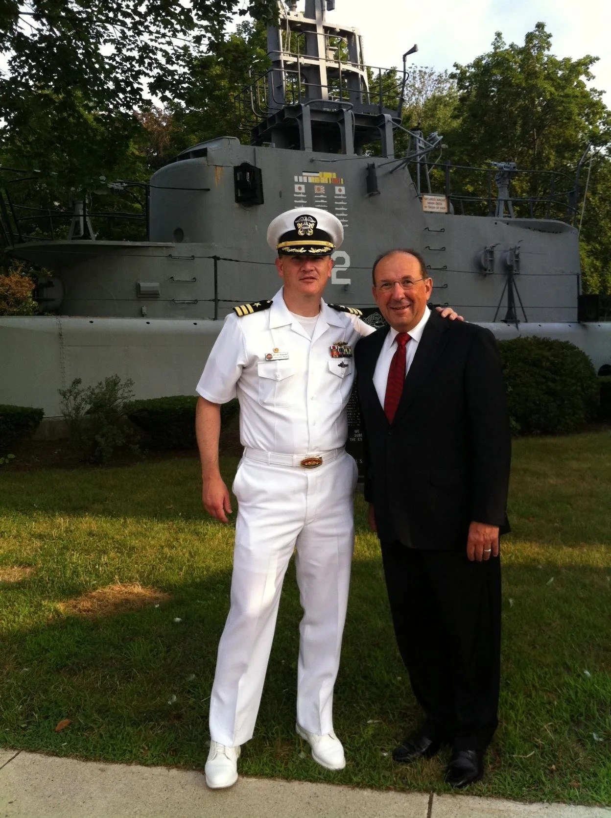 Capt John McGunnigle in dress whites and John Ranelli in suit with submarine behind