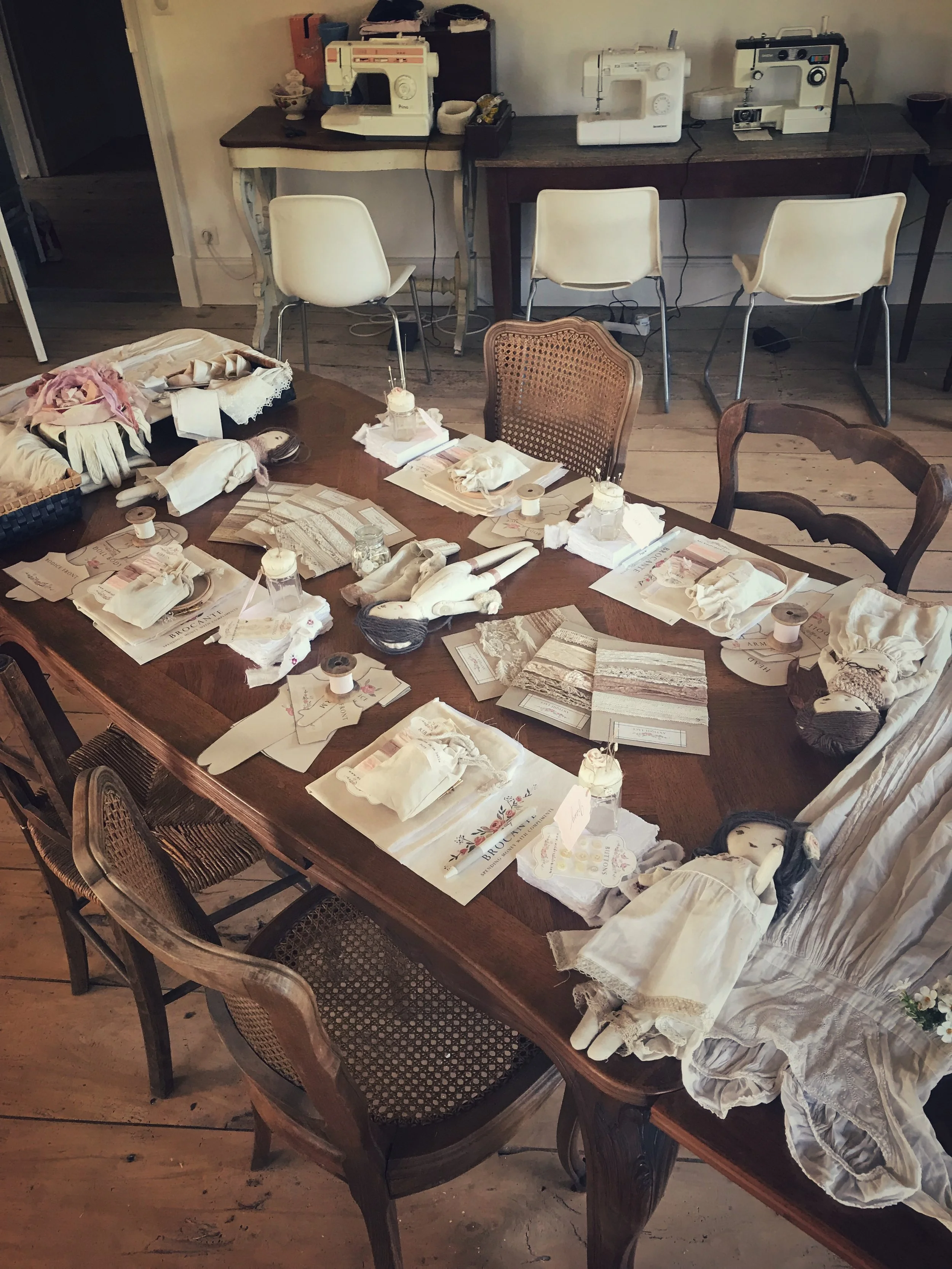 Vintage château table setting with china, flowers and fairy lights during a Wilderstitch sewing retreat in France.