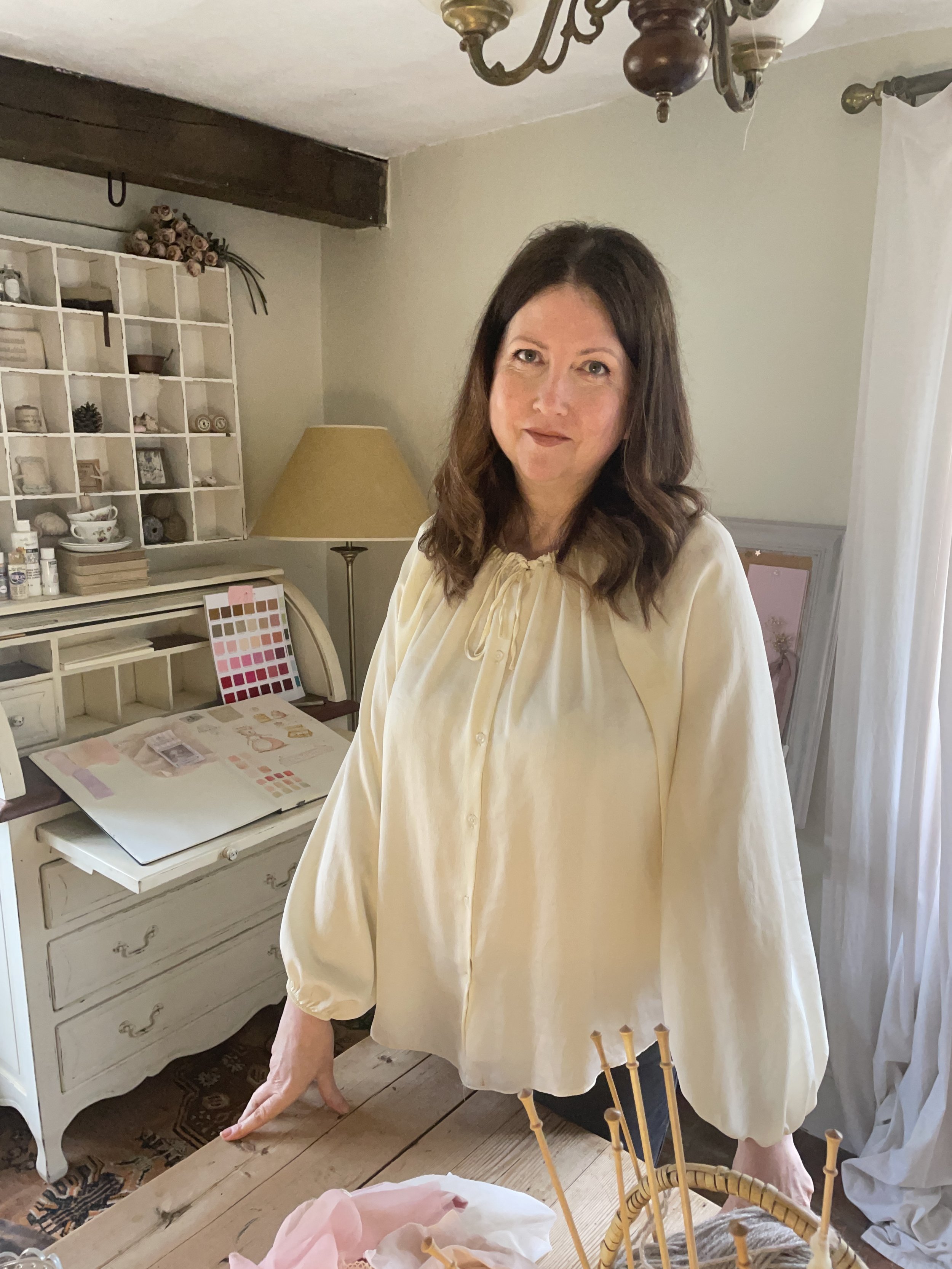 Erica-Jane Waters in the Wilderstitch studio surrounded by sewing patterns, fabrics and creative work.