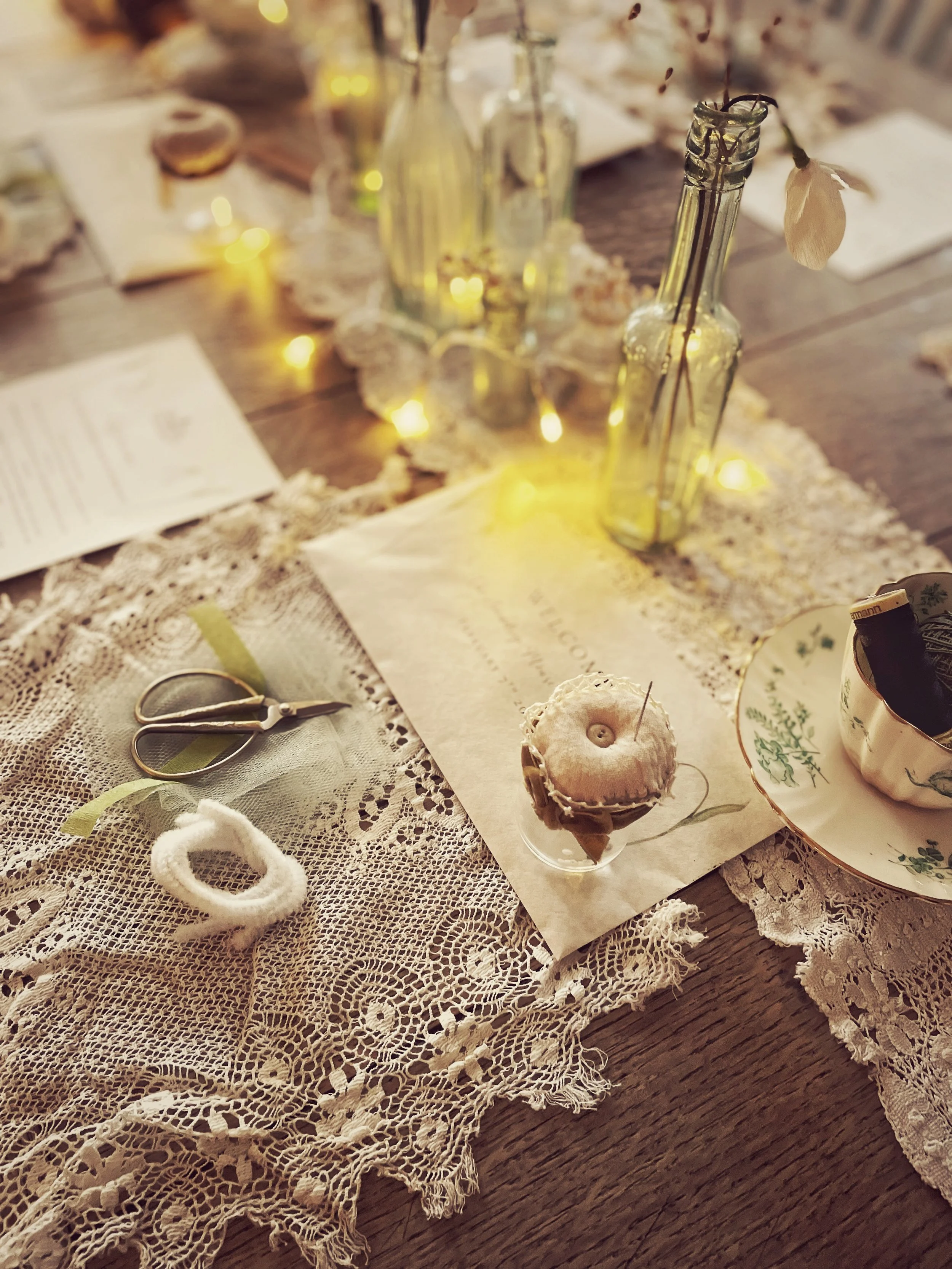 Vintage-style table laid with sewing materials, tea and homemade treats for a Wilderstitch sewing workshop.