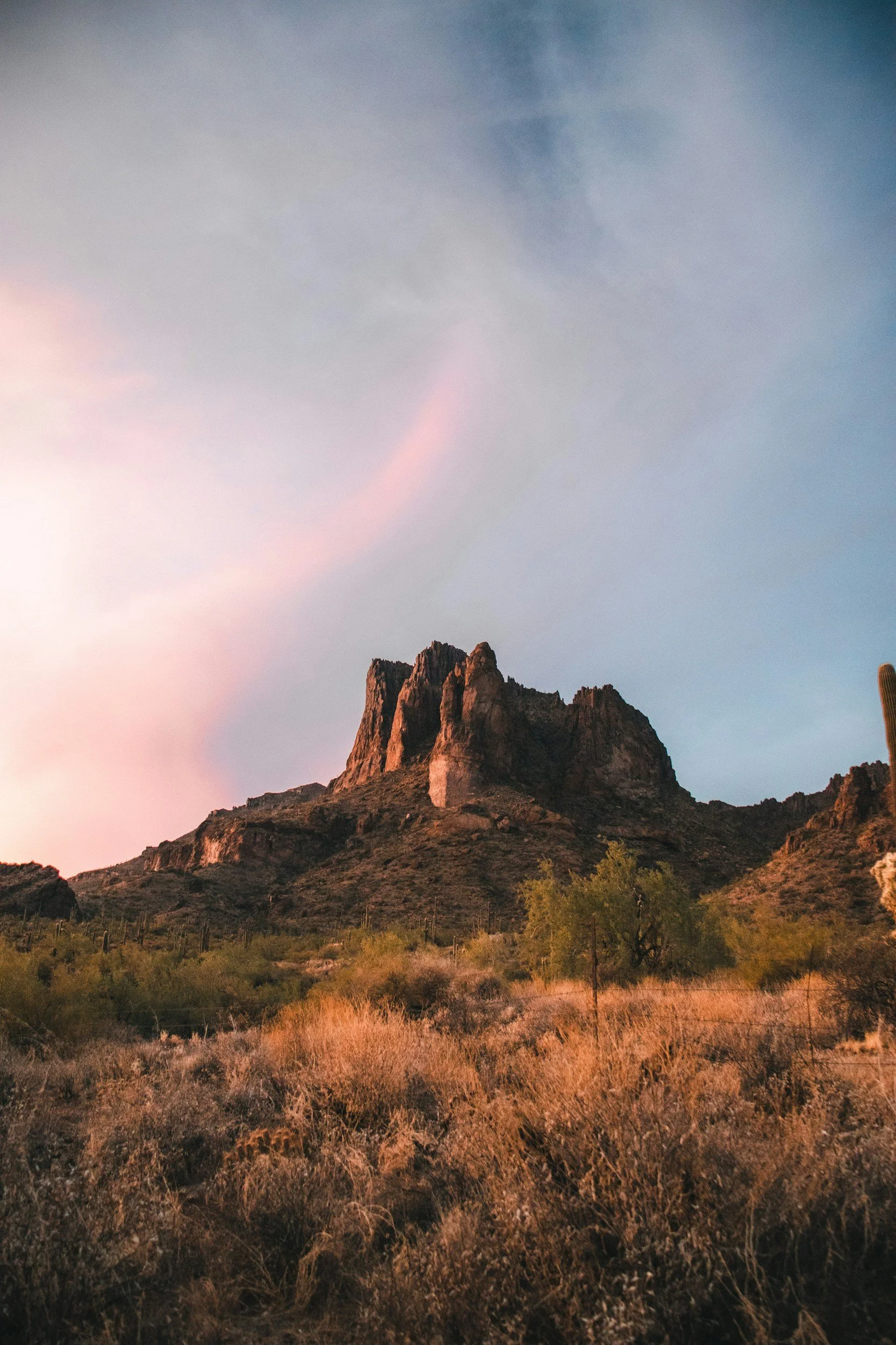 Desert Mountain Landscape at sunset with warm orange rock formations and vegetation