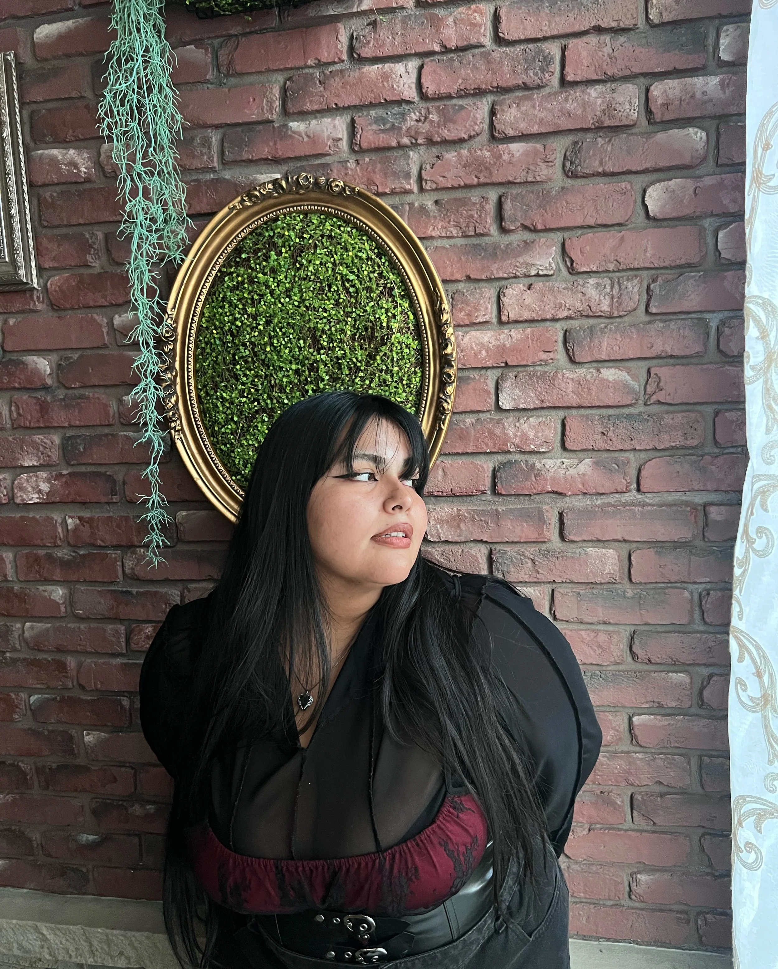 Close-up of swirling paint with vibrant yellow, orange, red, green, and black colors creating an abstract pattern.