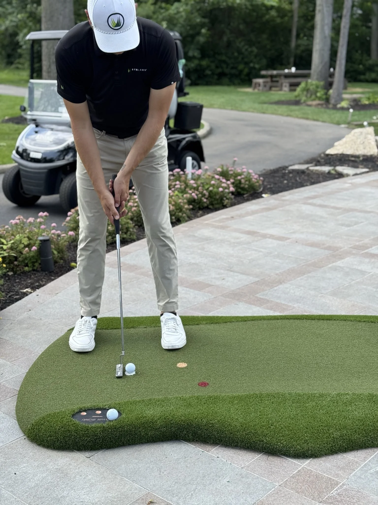 Golfer getting ready to putt a golf ball on an artificial putting green