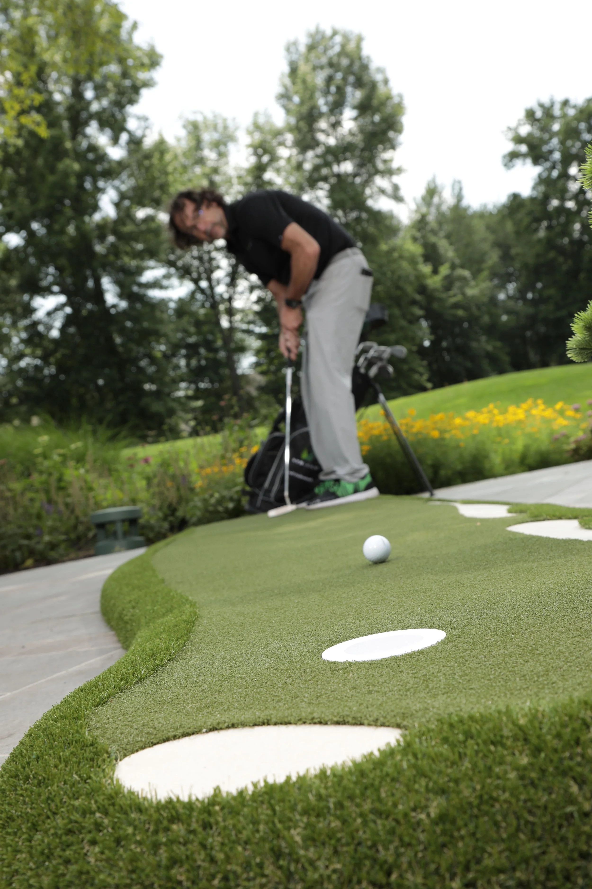 Golfer about to hit a golf ball on an artificial grass putting green