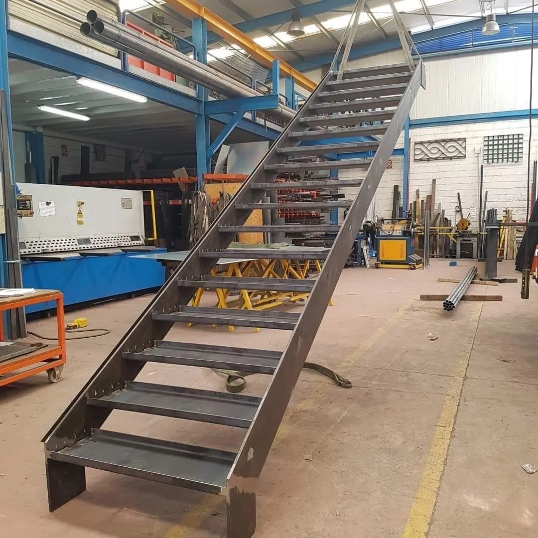 Metal staircase frame in a manufacturing workshop.
