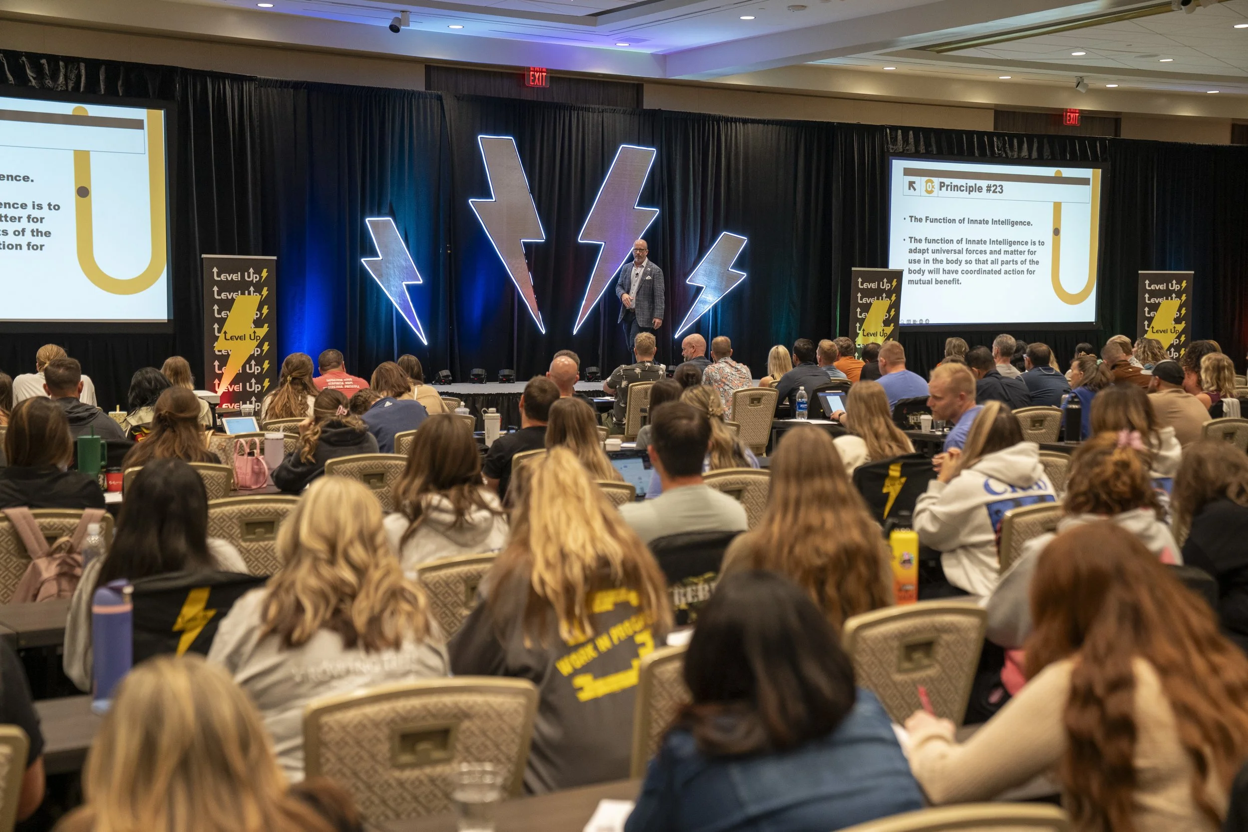 Dr. Eric Russell speaking to an audience at a chiropractic conference and educational event.