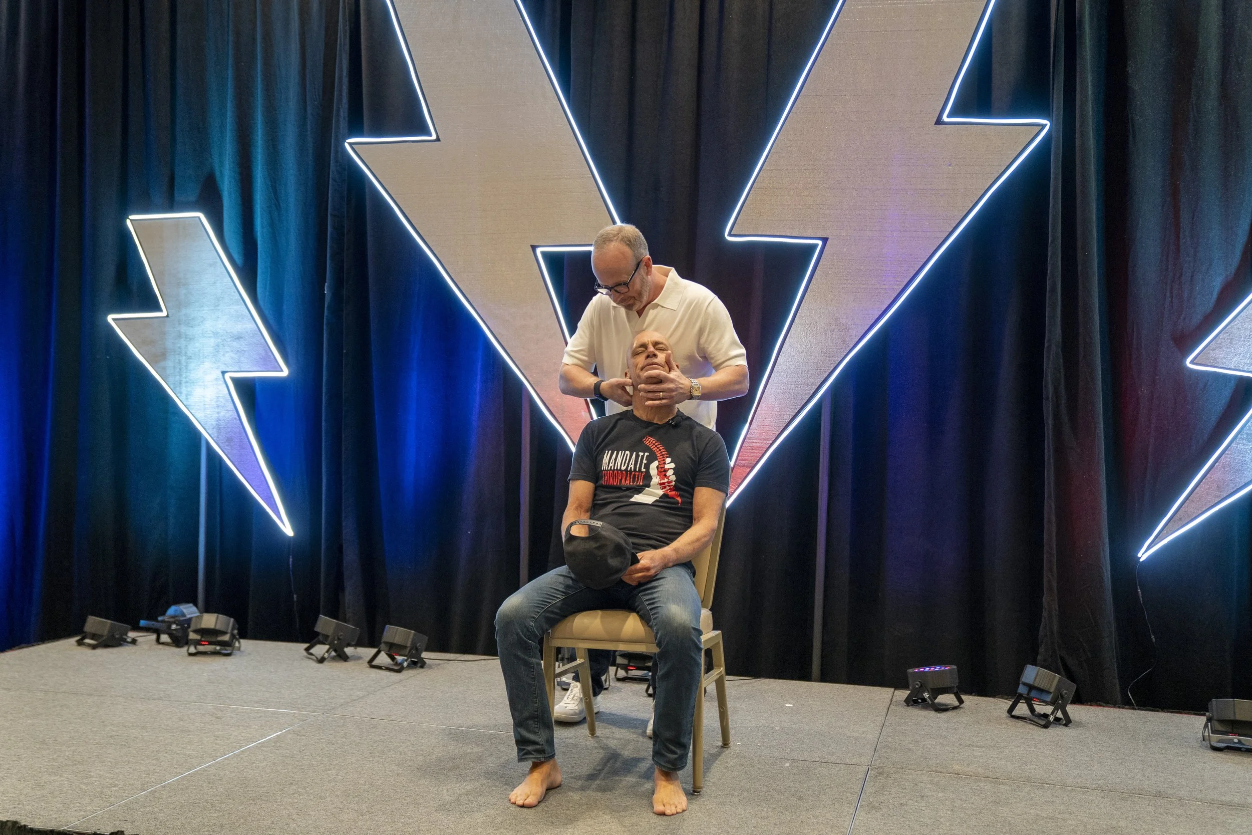 Dr. Eric Russell demonstrating chiropractic principles during a live chiropractic presentation with Dr. Billy DeMoss, creator of the California Jam seminar.