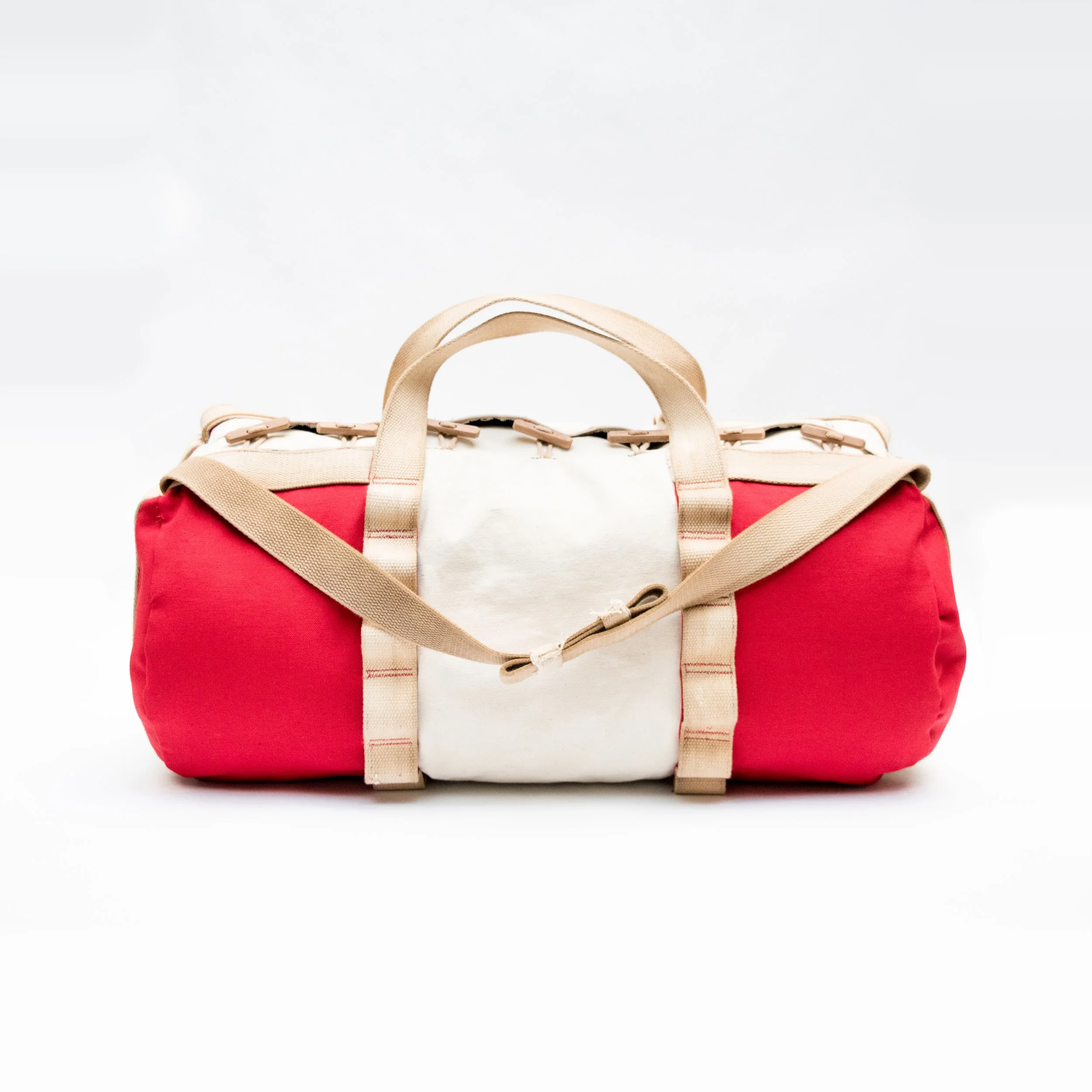 Red and white duffel bag with beige straps on a white background.