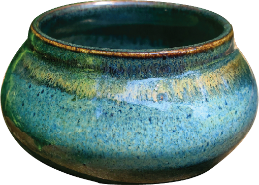 Close-up of a glazed ceramic bowl with a multicolored, textured surface in shades of blue and green.
