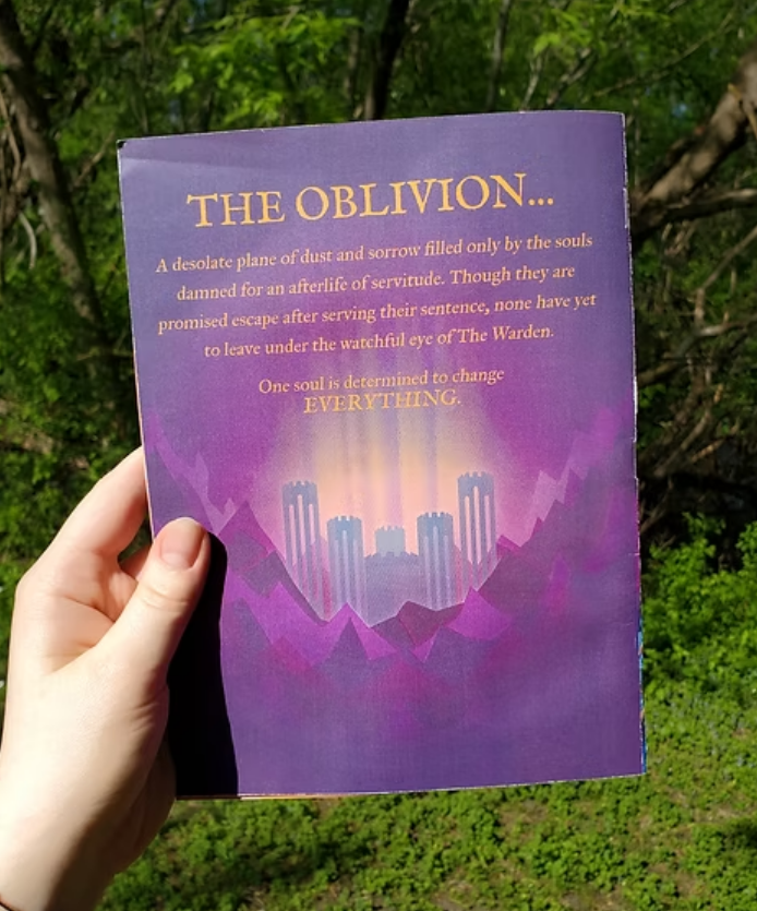 A person holding a purple book with the title 'The Oblivion...' against a background of green trees and foliage.