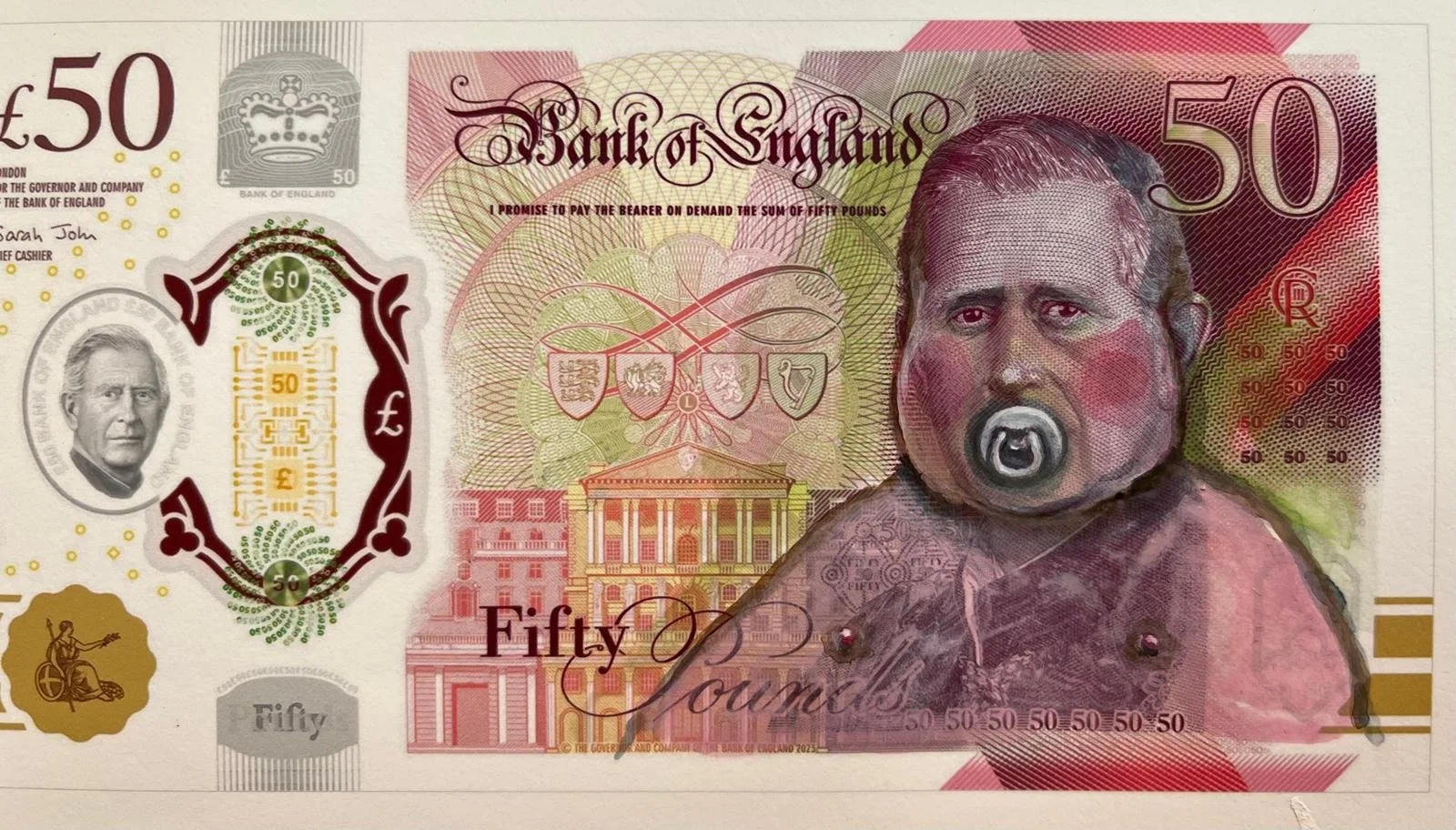 A modified fifty-pound British banknote featuring a painted portrait of a man with a pacifier in his mouth in place of the original image, alongside traditional banknote elements.