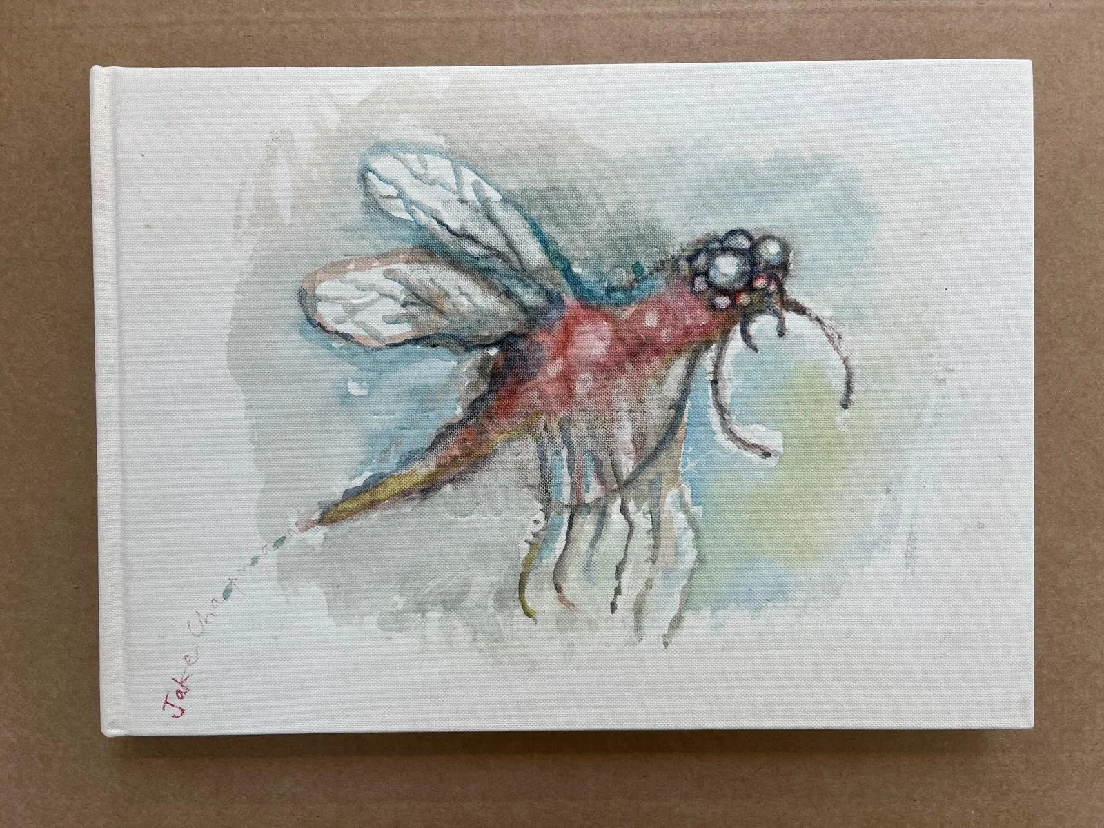 Watercolor painting of a dragonfly with blue and white wings and a reddish body on a neutral background, signed by the artist in the lower left corner.