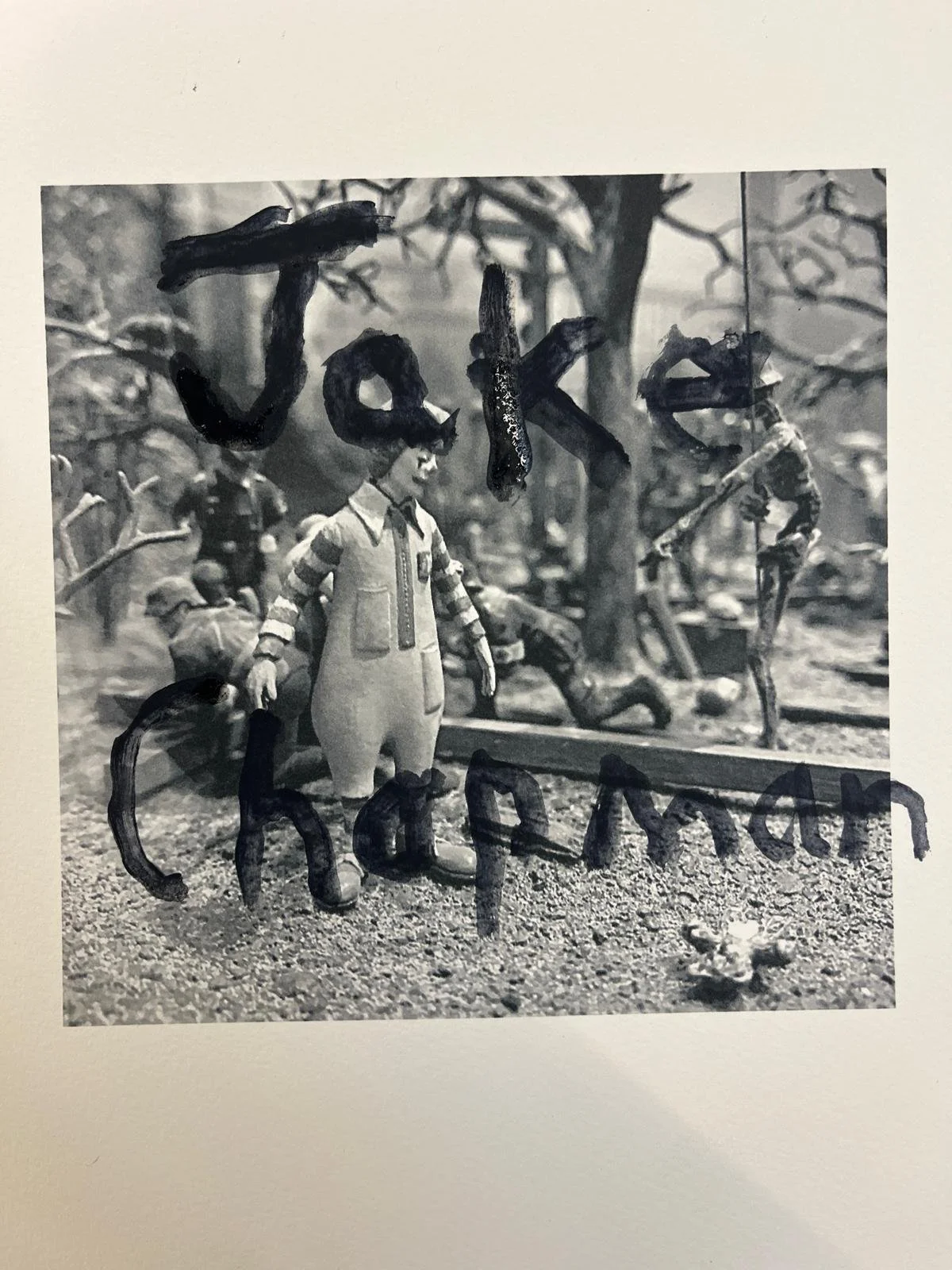 Close-up of a black-and-white model scene with a small boy figure standing on ground, with the words 'Take a break' written in large letters over the scene.