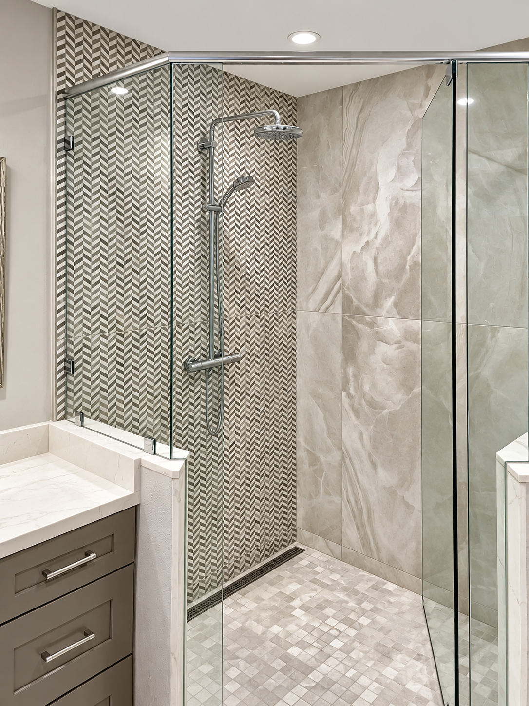 Frameless glass shower with a herringbone tile wall and a mosaic floor, bathroom remodel in Mountain View, CA