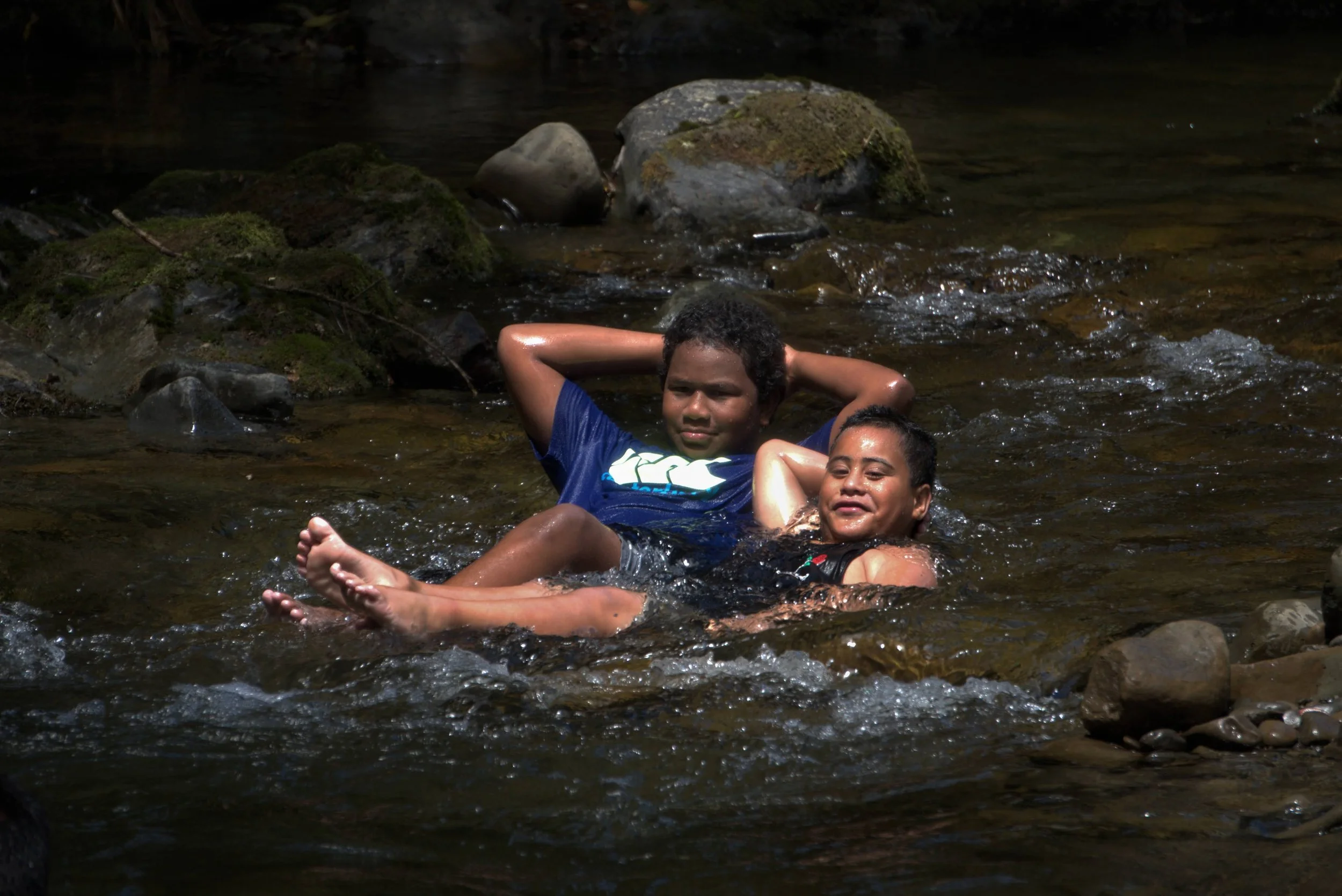 Two children swimming and relaxing in Waioeka River, Eastern Whio Link restoration project, with help from Leading from the Land Tairāwhiti