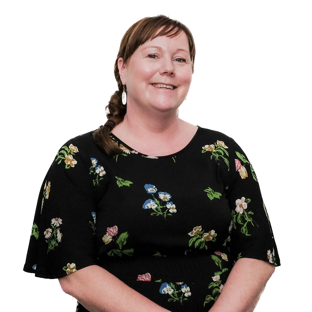 Portrait of a woman with brown hair and earrings, wearing a black floral dress, smiling.