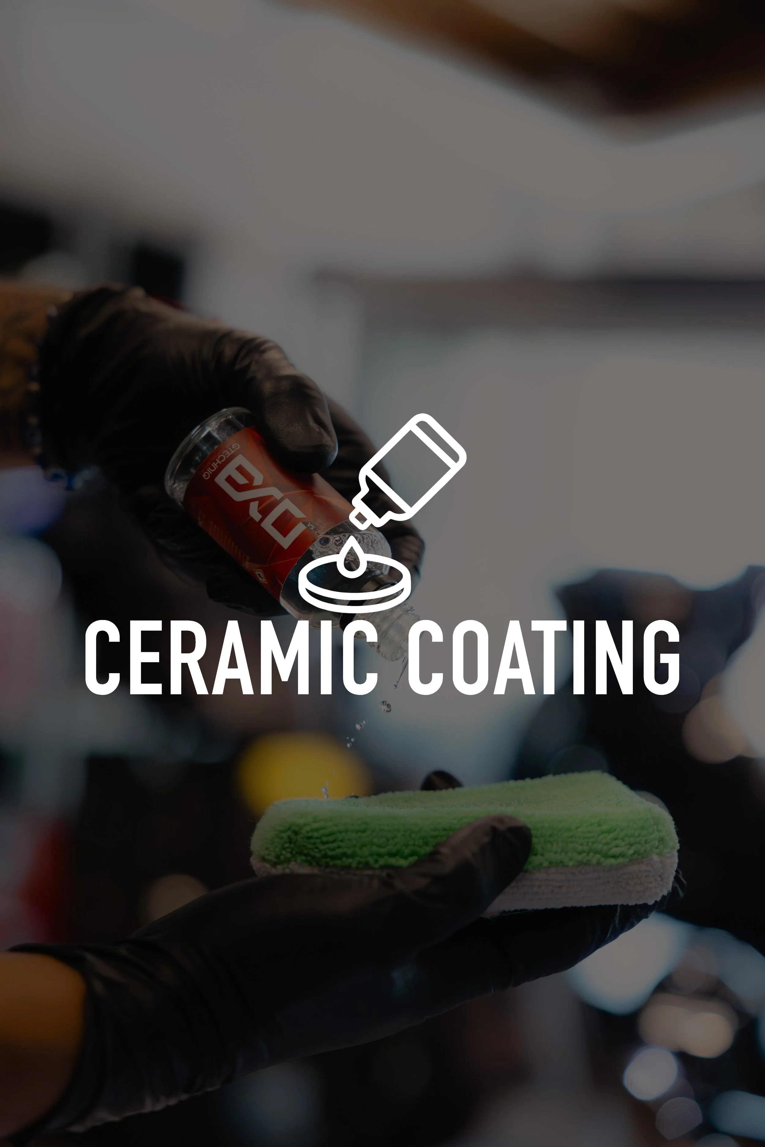 Person applying ceramic coating to a surface with a spray bottle, wearing black gloves, with a sponge in the foreground.