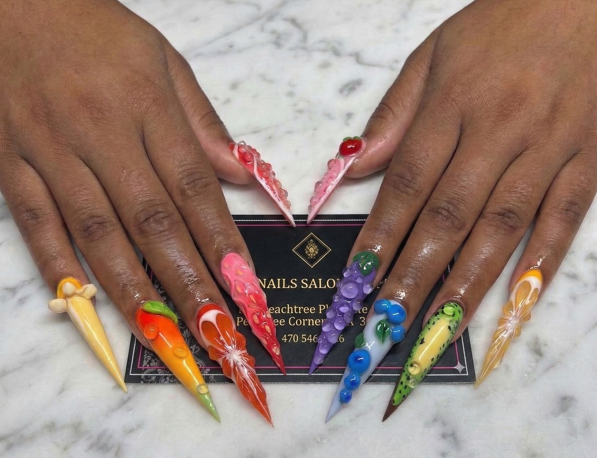 Hand with Halloween-themed nail art holding a business card from TT Nails Salon & Spa.