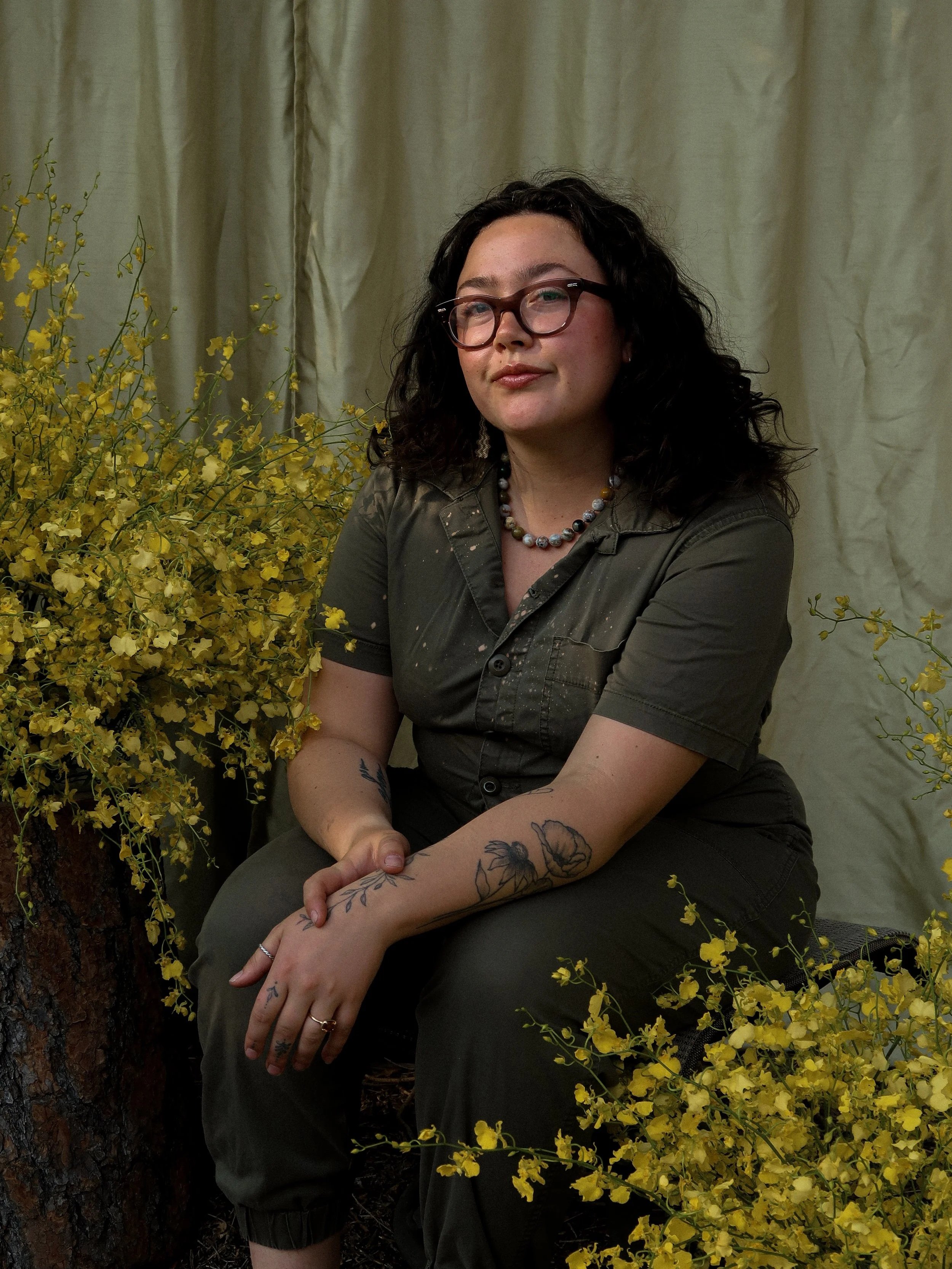 Floral artist with oncidium orchids flanking the scene. Designer creating florals for weddings in Colorado. Colorado wildflower wedding bouquet