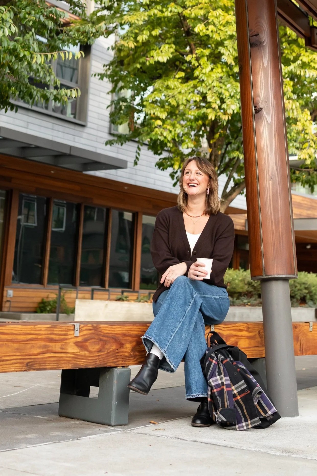 Scenic landscape with a large body of water, rolling green hills, and tall mountains under a cloudy sky.