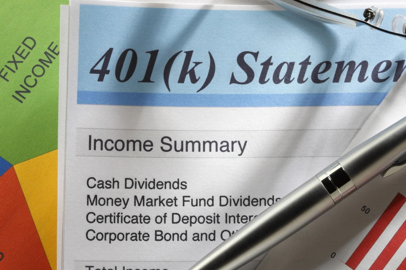 Close-up of a financial document titled '401(k) Statement' with a pen resting on it, showing an income summary including cash dividends, money market fund dividends, and a certificate of deposit interest.