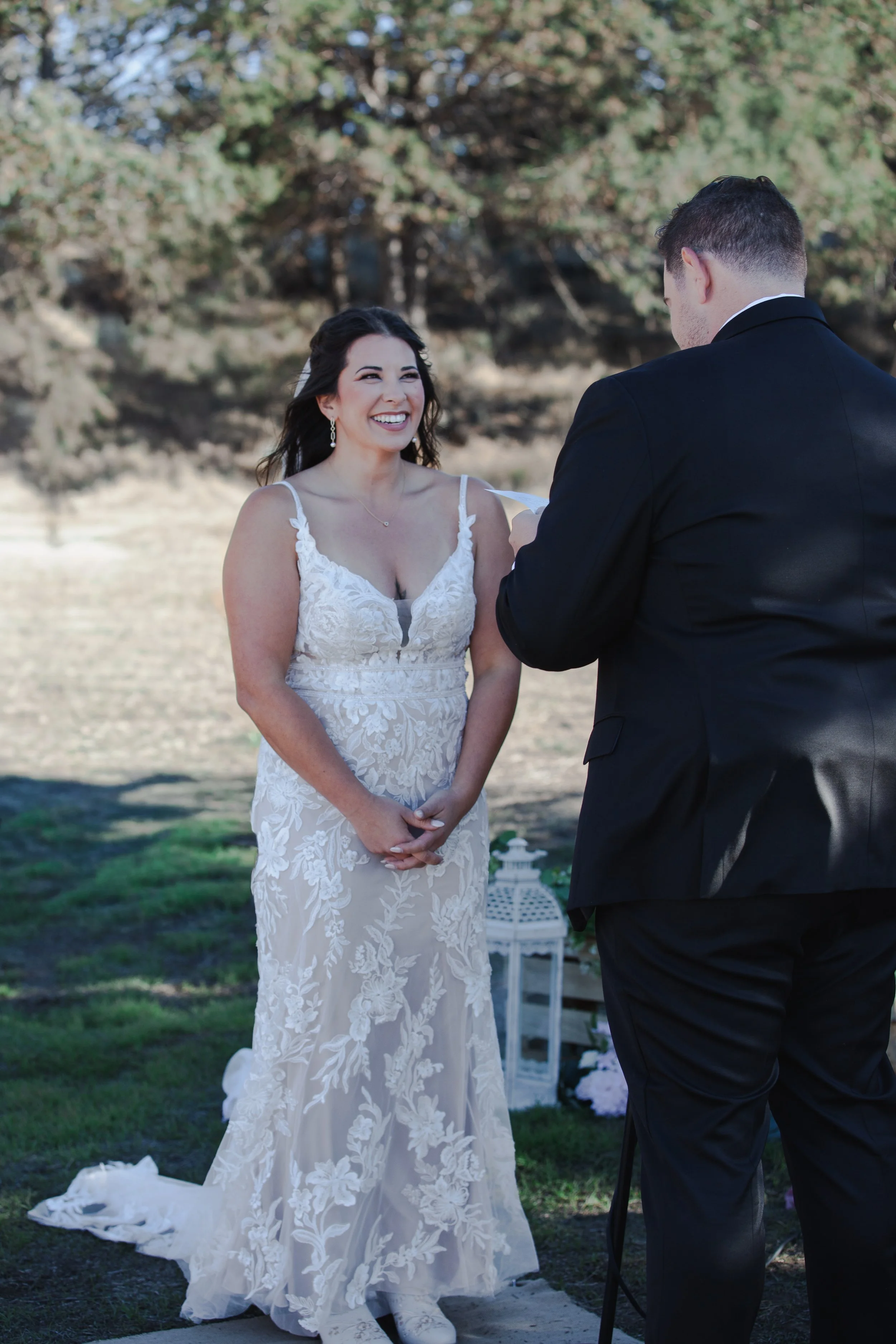 Bride smiling at her groom during their outdoor ranch wedding ceremony near Bend, Oregon.
