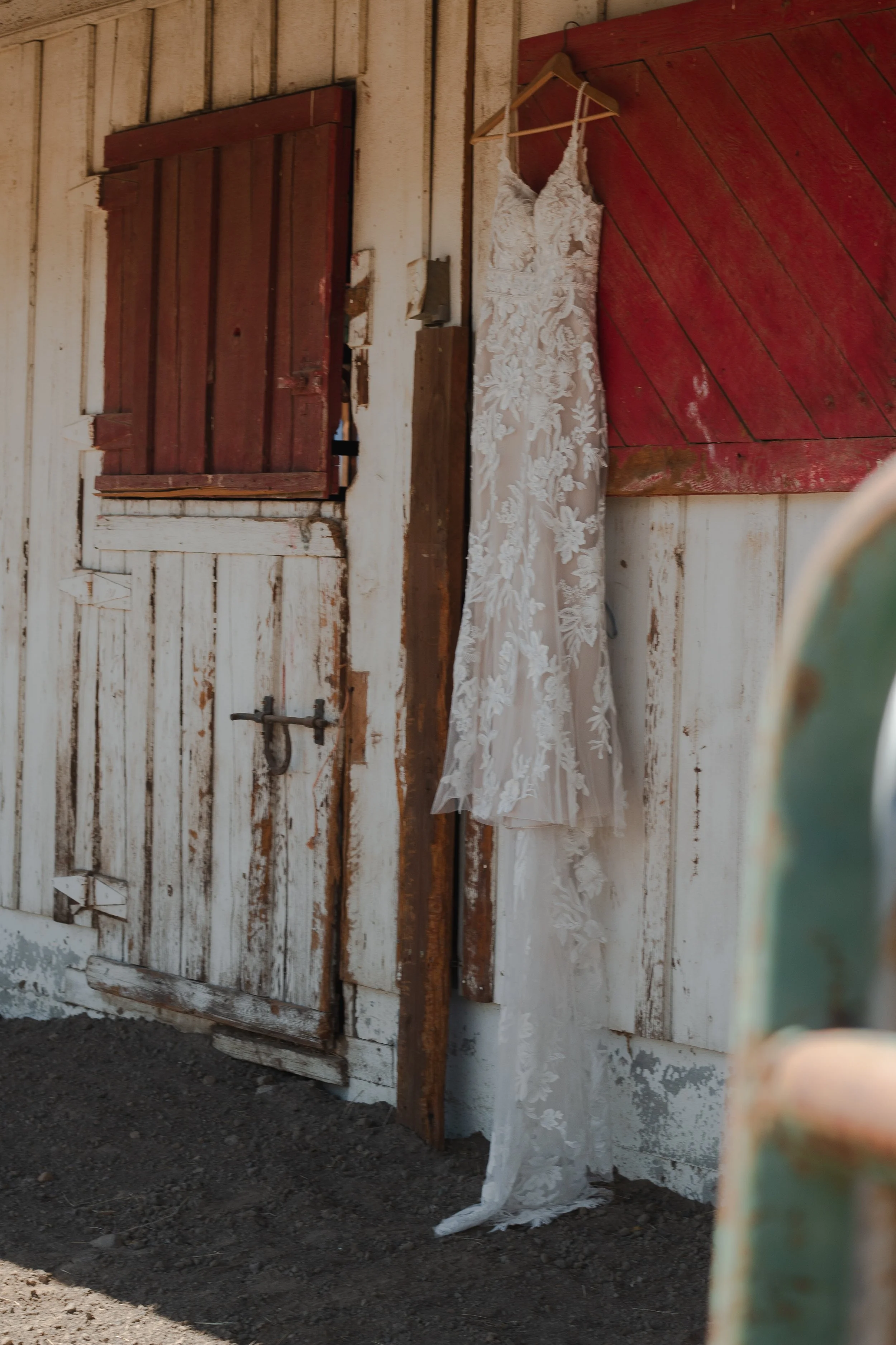  Wedding dress hanging inside a rustic ranch building before a summer wedding near Bend, Oregon 