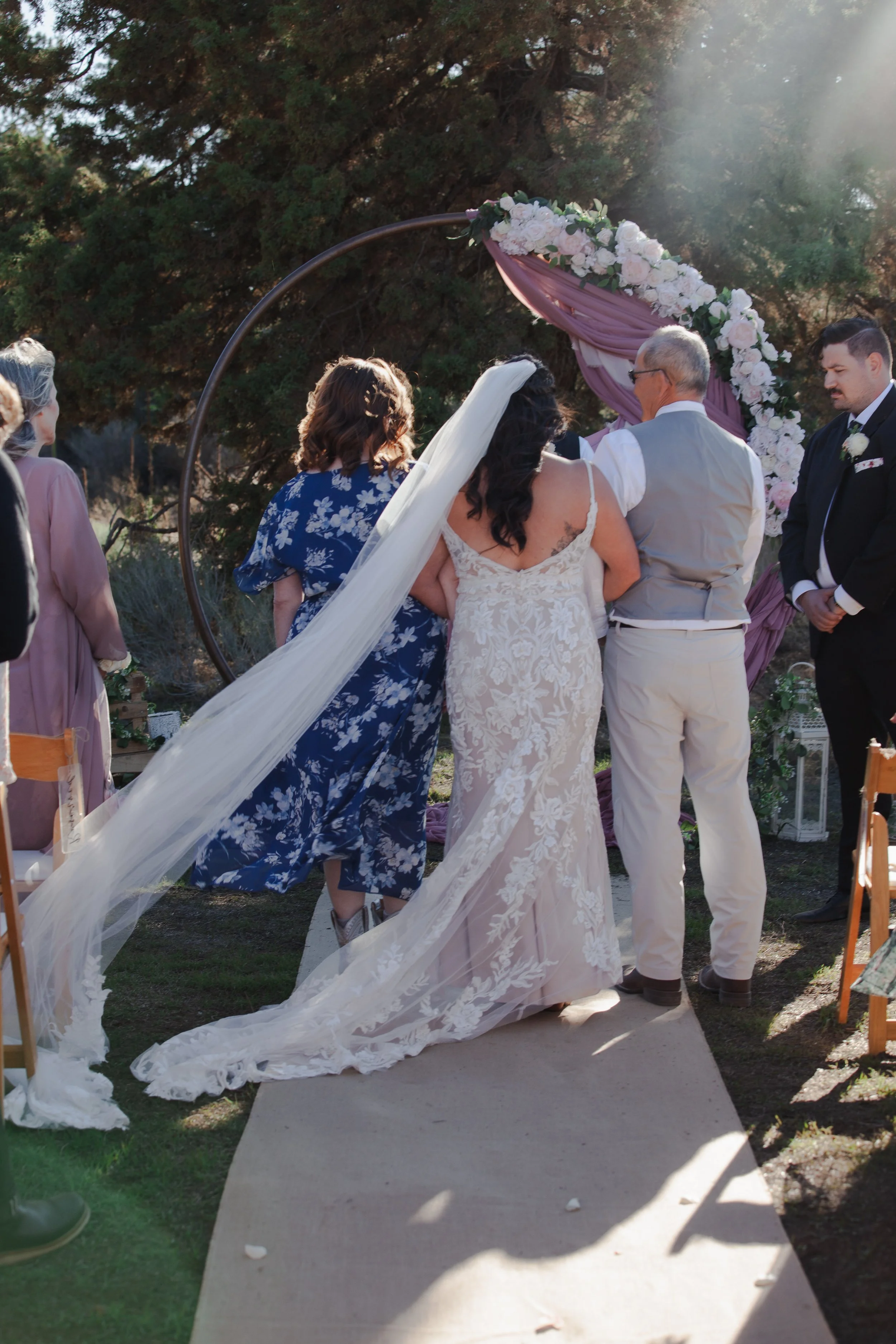  Groom's father officiating an intimate outdoor wedding ceremony on a private ranch near Bend, Oregon 