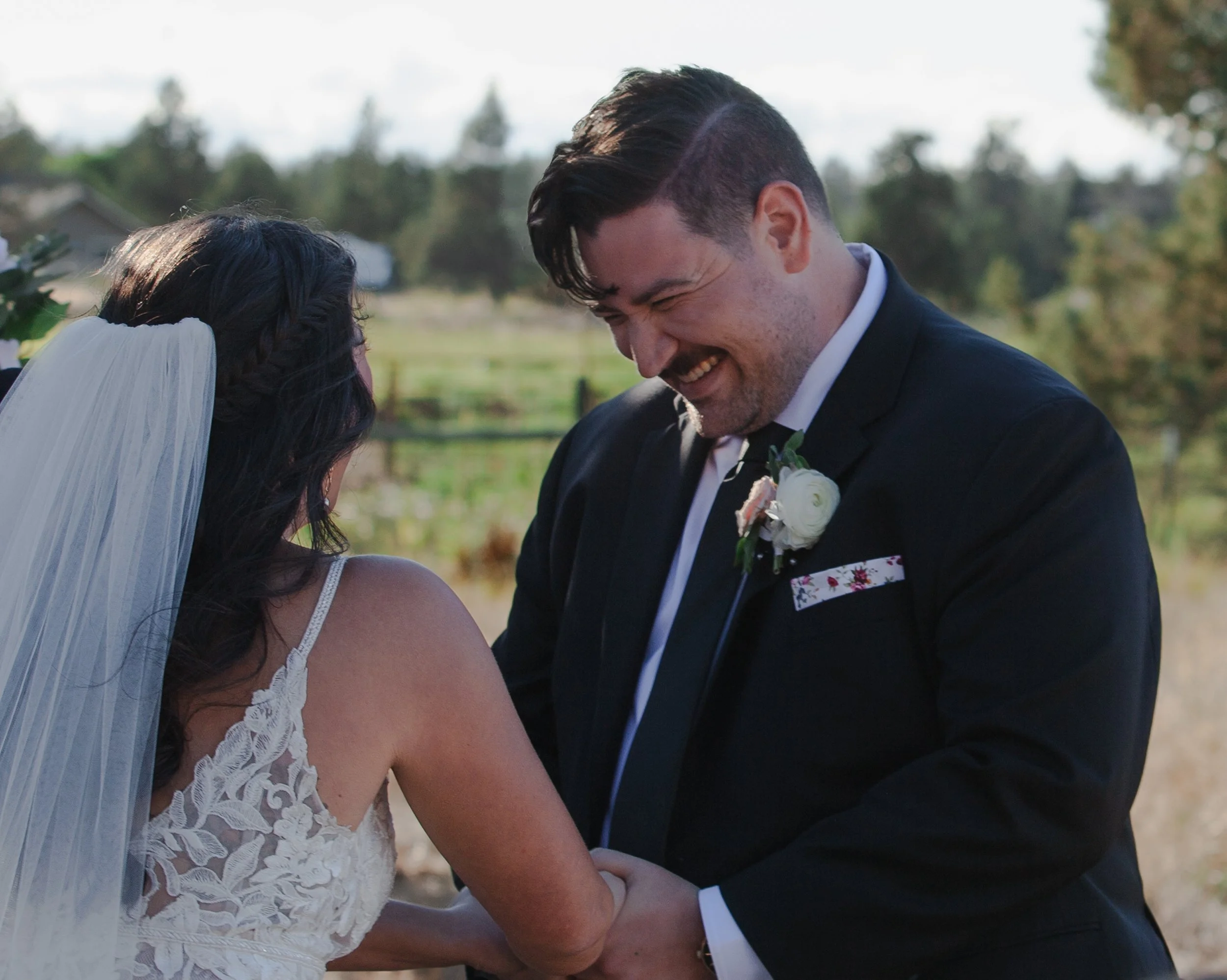  Bride and groom laughing while exchanging personal vows at their Central Oregon ranch wedding 