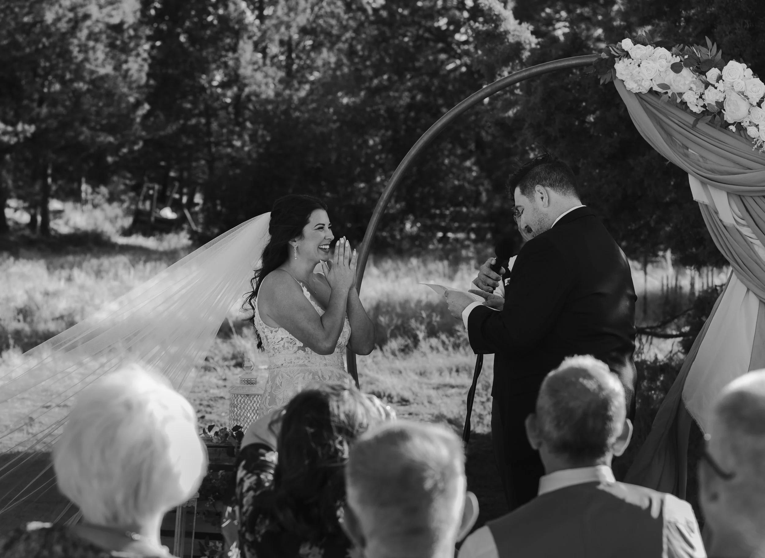  Bride and groom laughing while exchanging personal vows at their Central Oregon ranch wedding 