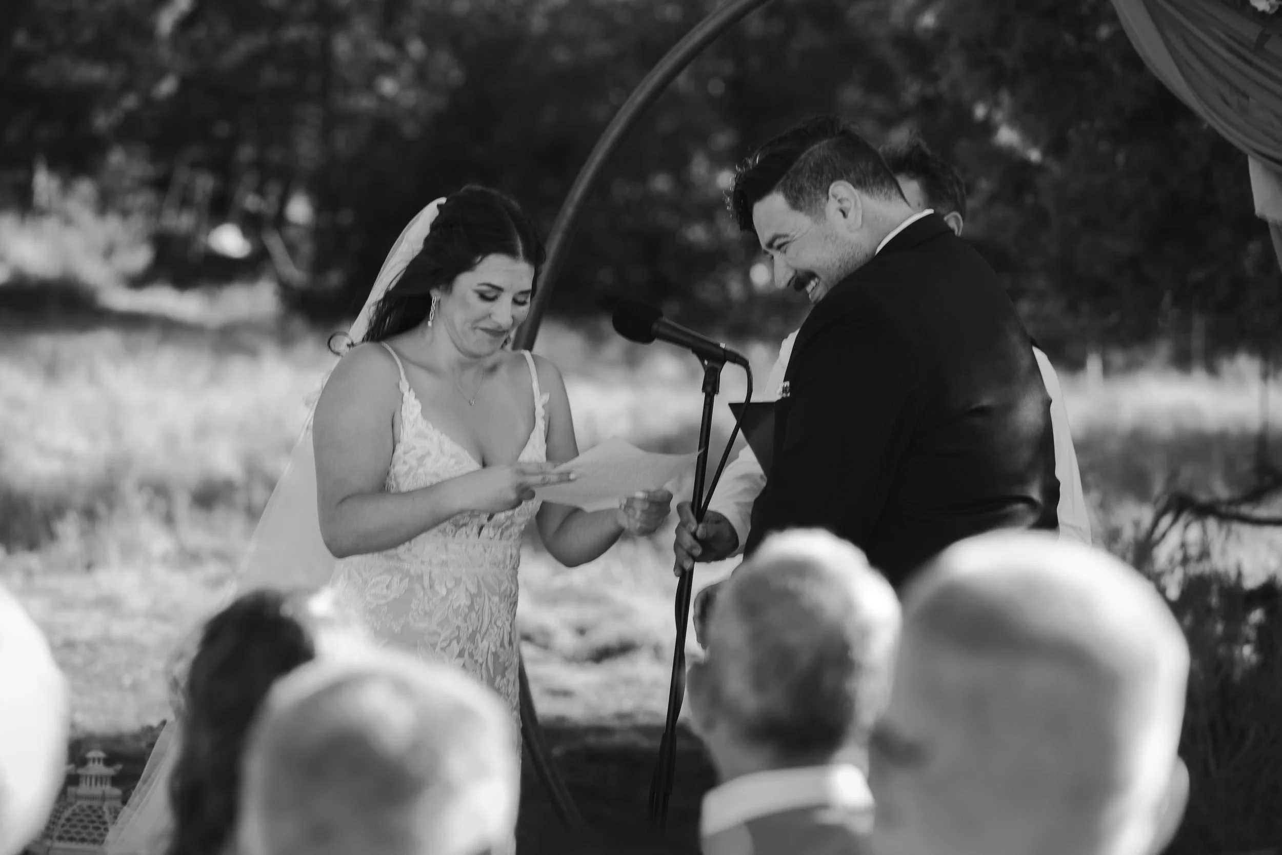  Bride and groom laughing while exchanging personal vows at their Central Oregon ranch wedding 