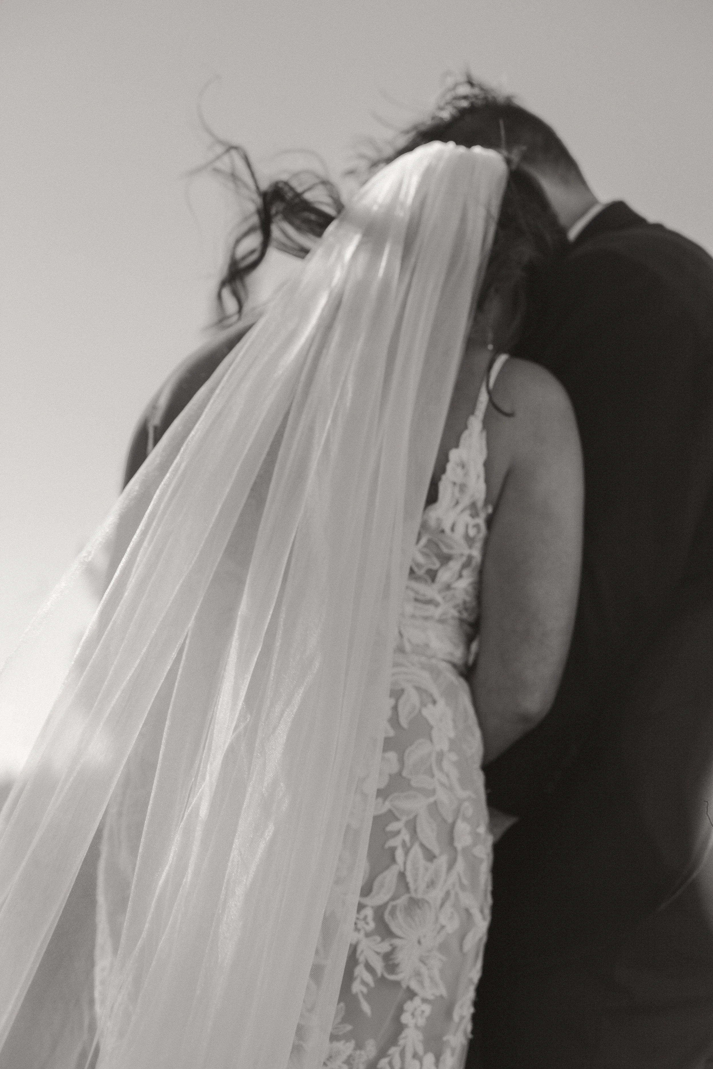  Black and white photograph of the newlyweds kissing after their outdoor ranch wedding ceremony in Bend, Oregon 