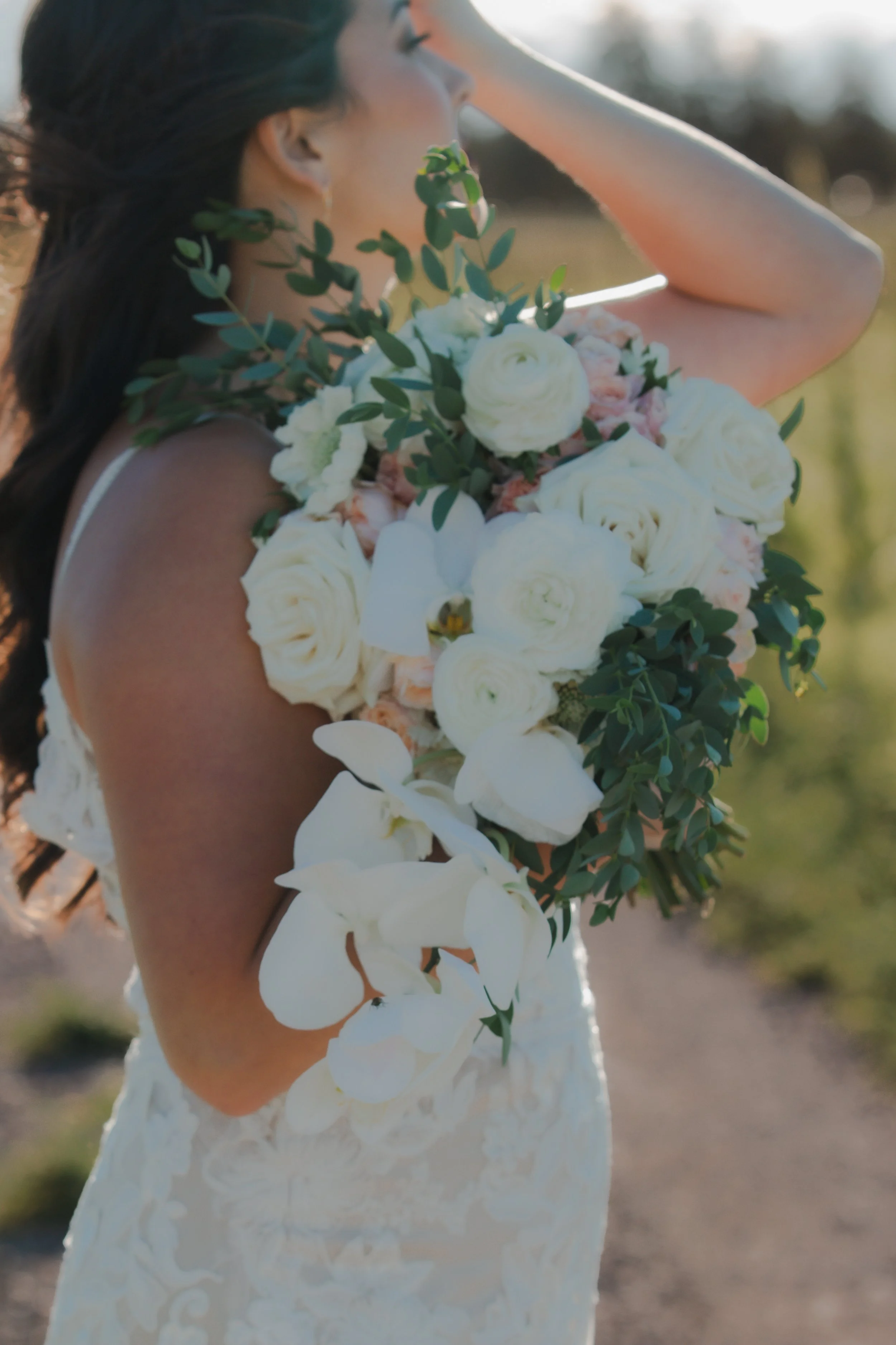  Bride carrying a white floral bouquet during her summer ranch wedding near Bend, Oregon 