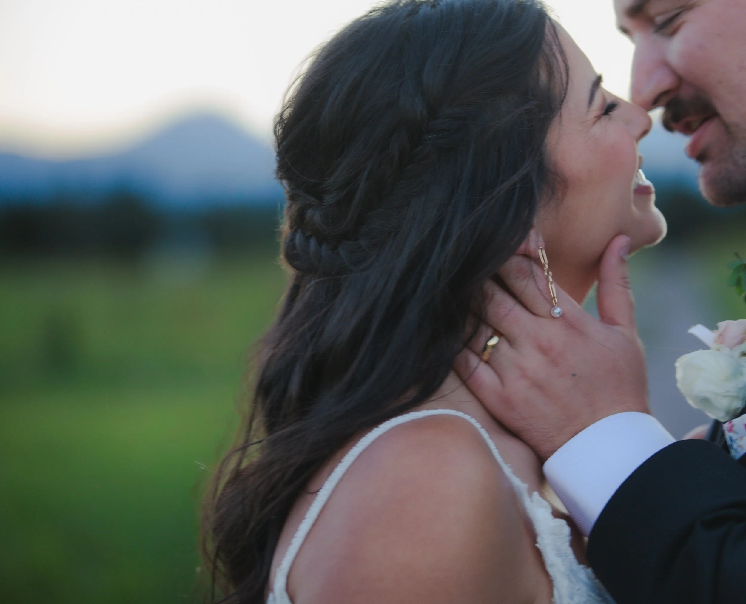  Newlyweds kissing beneath the Three Sisters mountains at sunset after their Bend, Oregon ranch wedding 