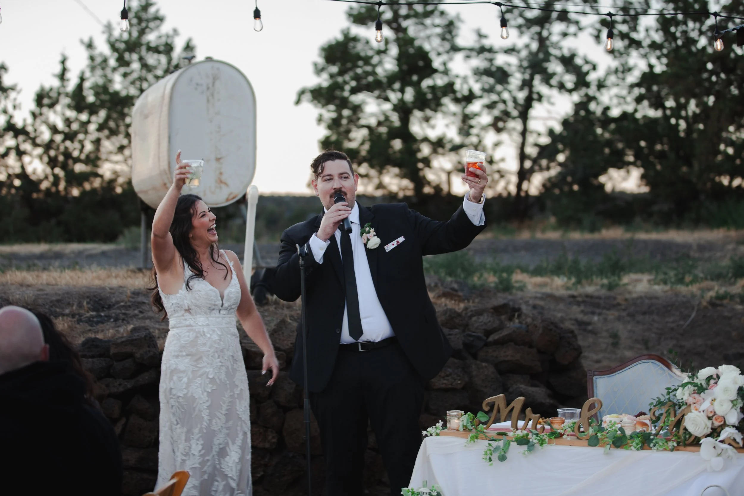  Bride and groom laughing during wedding toasts at their private ranch reception in Bend, Oregon 