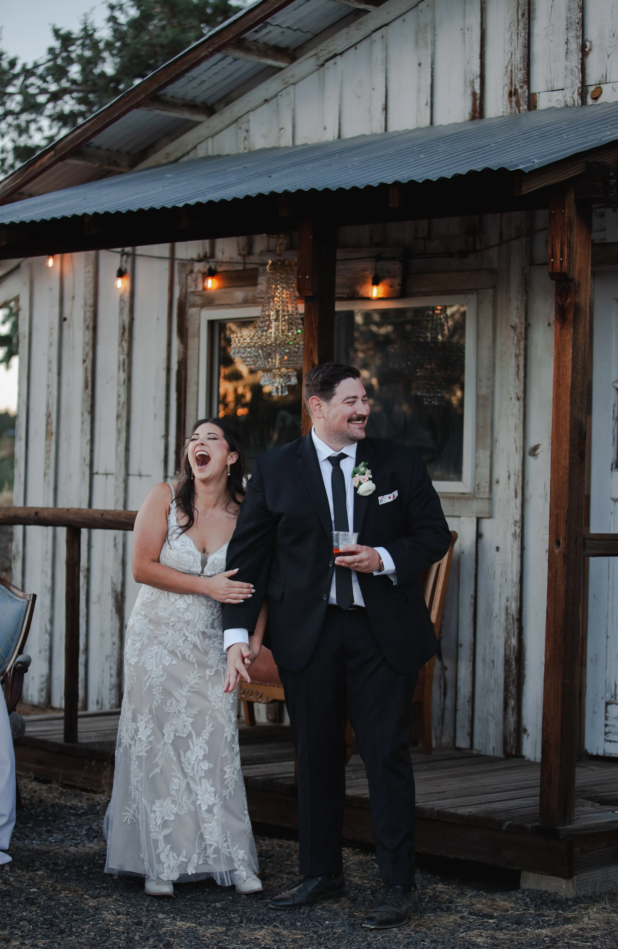  Bride and groom laughing during wedding toasts at their private ranch reception in Bend, Oregon 