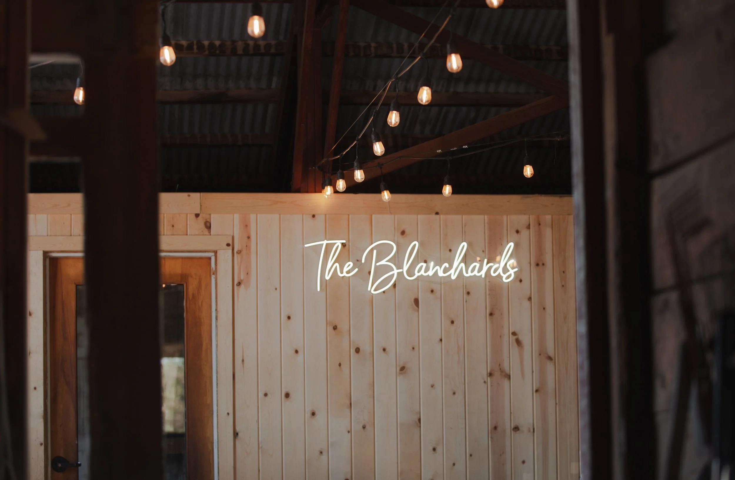  The Blanchards wedding sign beneath string lights inside their private ranch reception in Central Oregon 