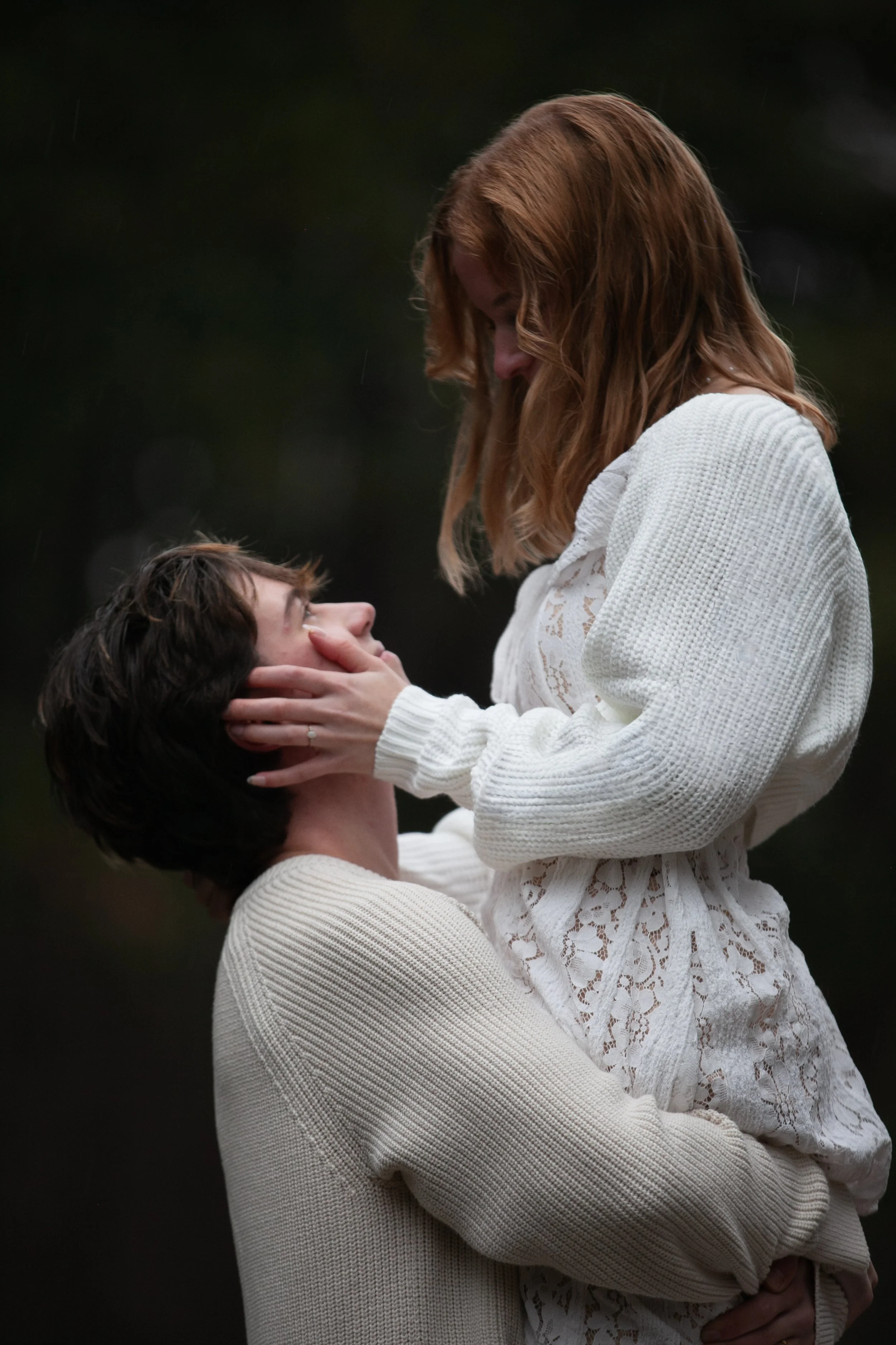 Playful engagement photo of a groom lifting his bride beside Lake Creek Lodge in Camp Sherman.