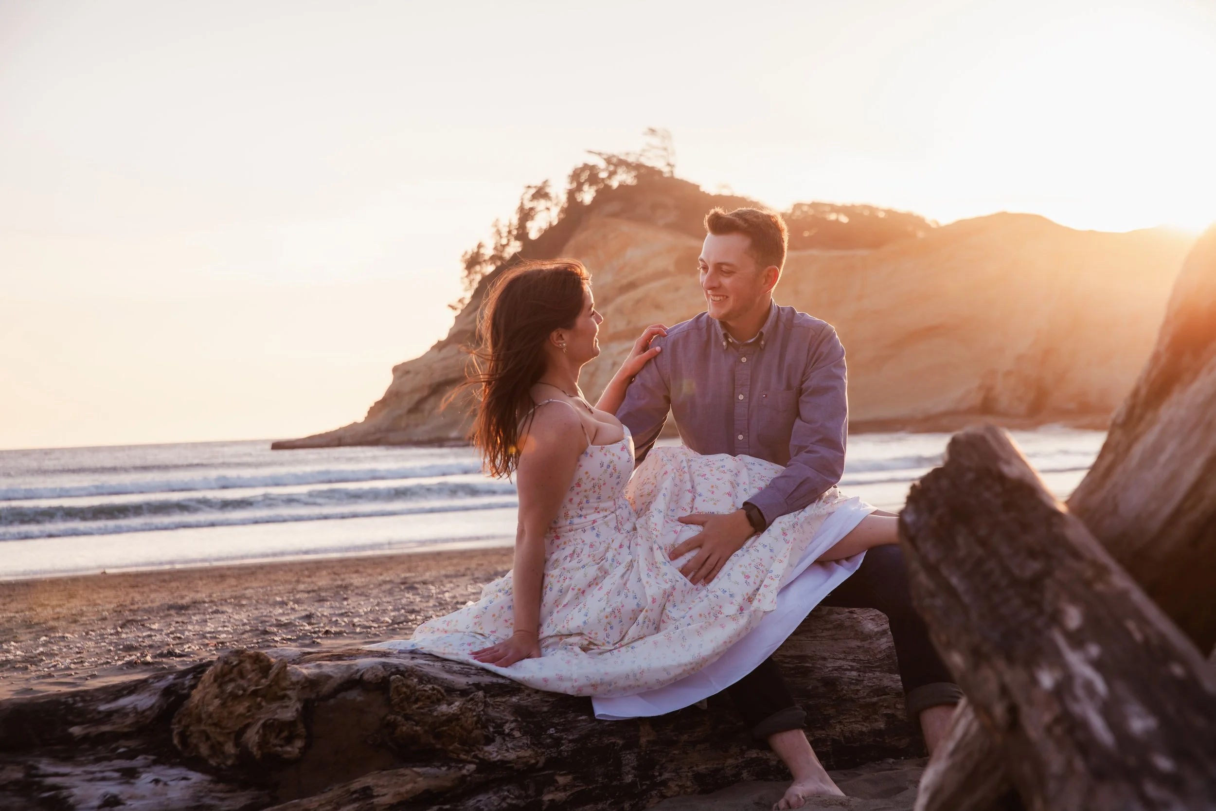 Bride and groom laughing together in golden evening light during their Pacific City engagement photos.