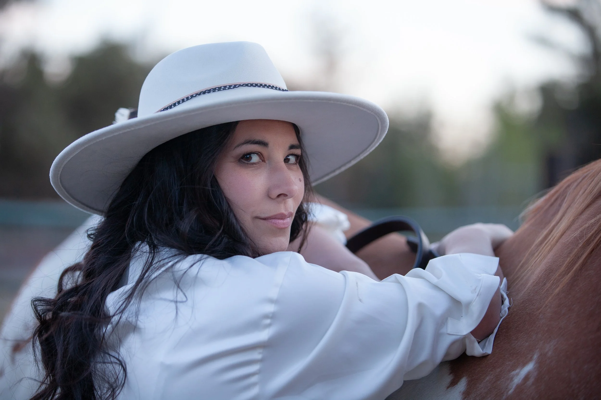 Editorial engagement portrait of a bride-to-be in a white Western hat during golden hour near Bend, Oregon.